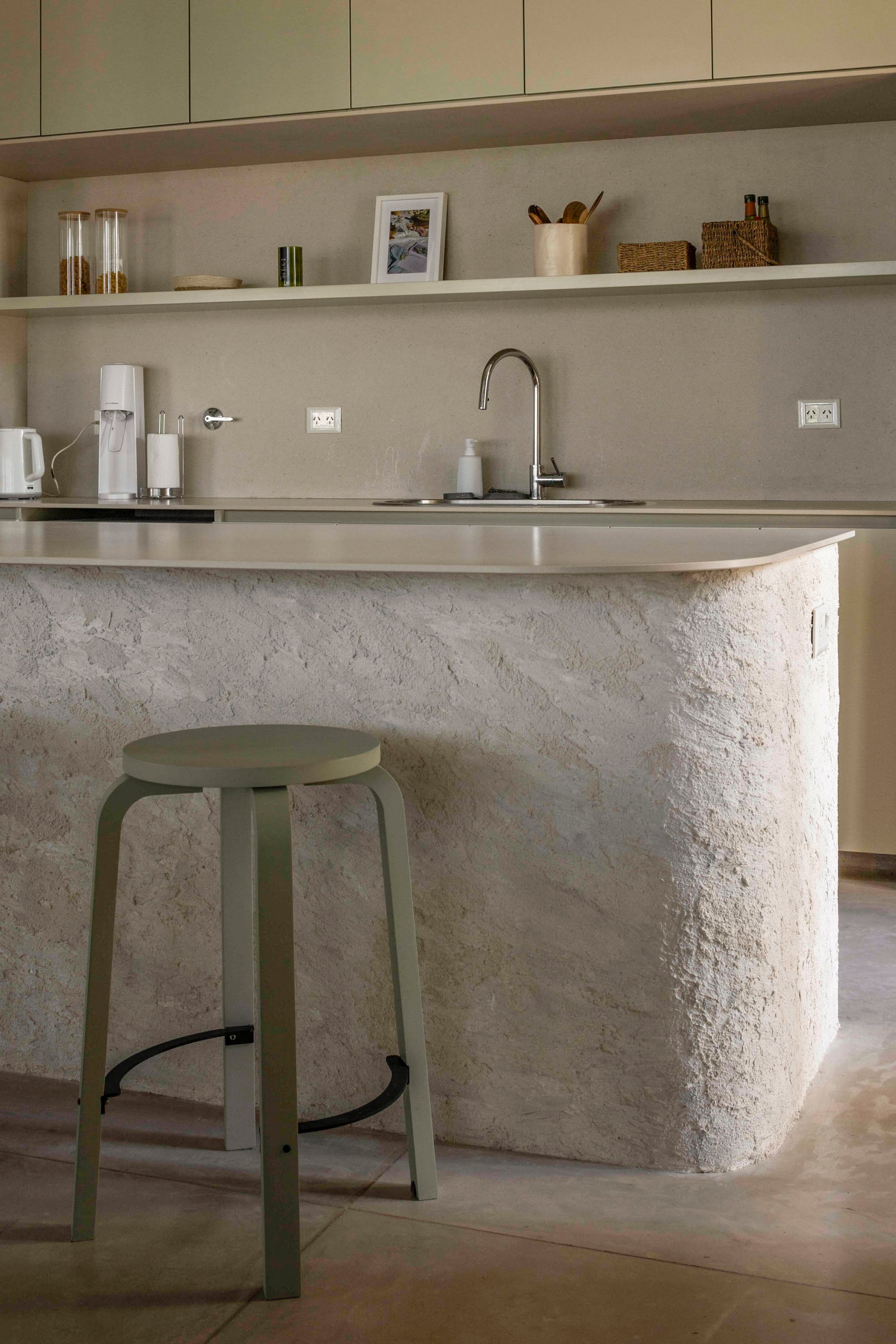 La base de la isla fue texturada artesanalmente por Lucía Molina. Tapa de ‘Prima Limestone’ (Purastone). Banqueta (Tortuga).