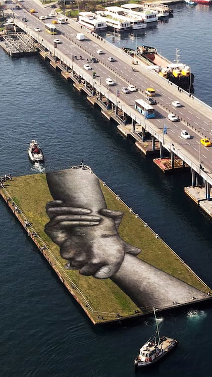 Una vista aérea muestra una obra del artista callejero franco-suizo Saype llamada "Beyond Walls" en una barcaza flotante sobre el Cuerno de Oro en Estambul, Turquía