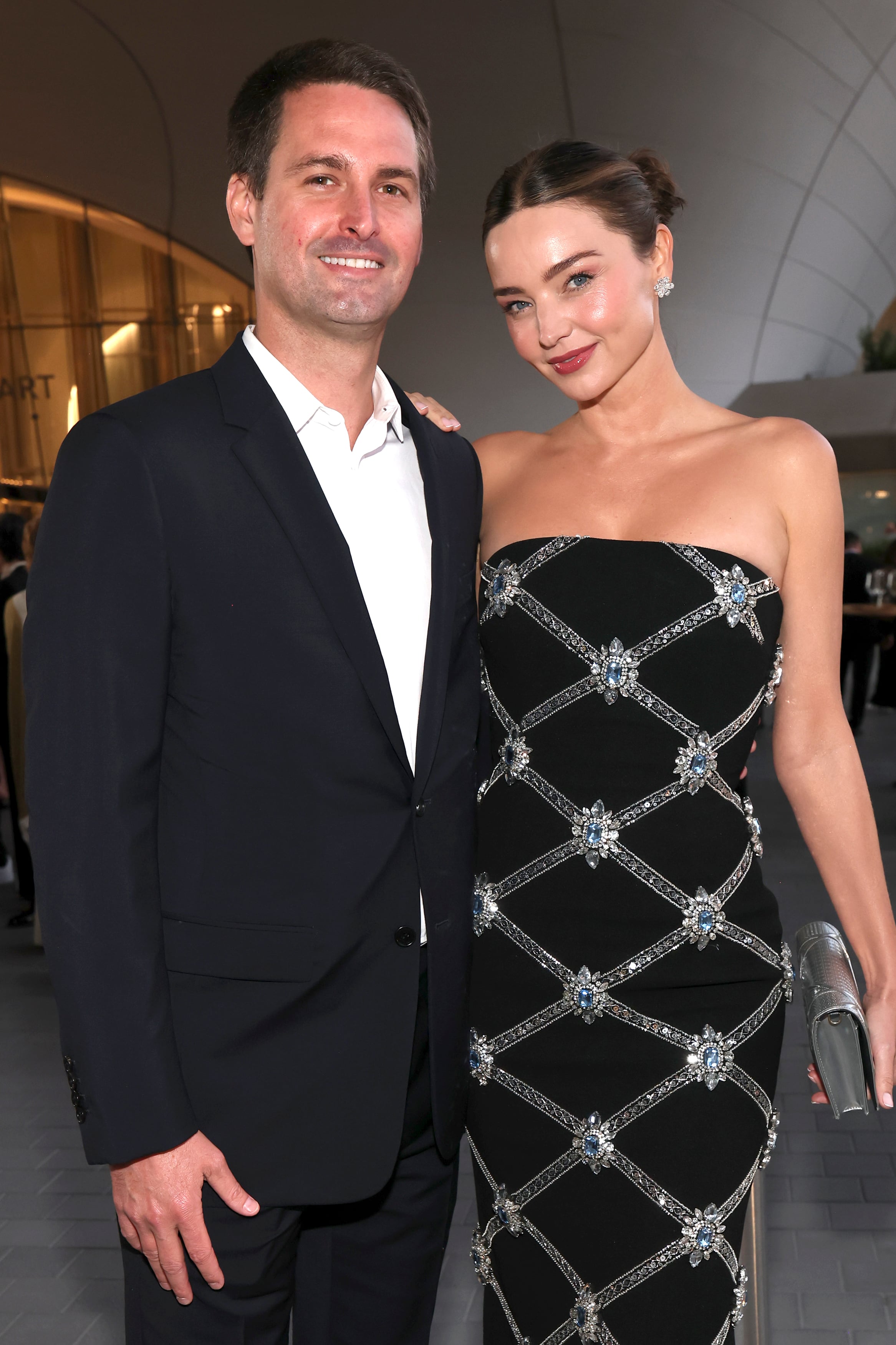 Evan Spiegel y Miranda Kerr, quien lució un strapless de Rebecca Vallance en negro con detalles en plata y piedras