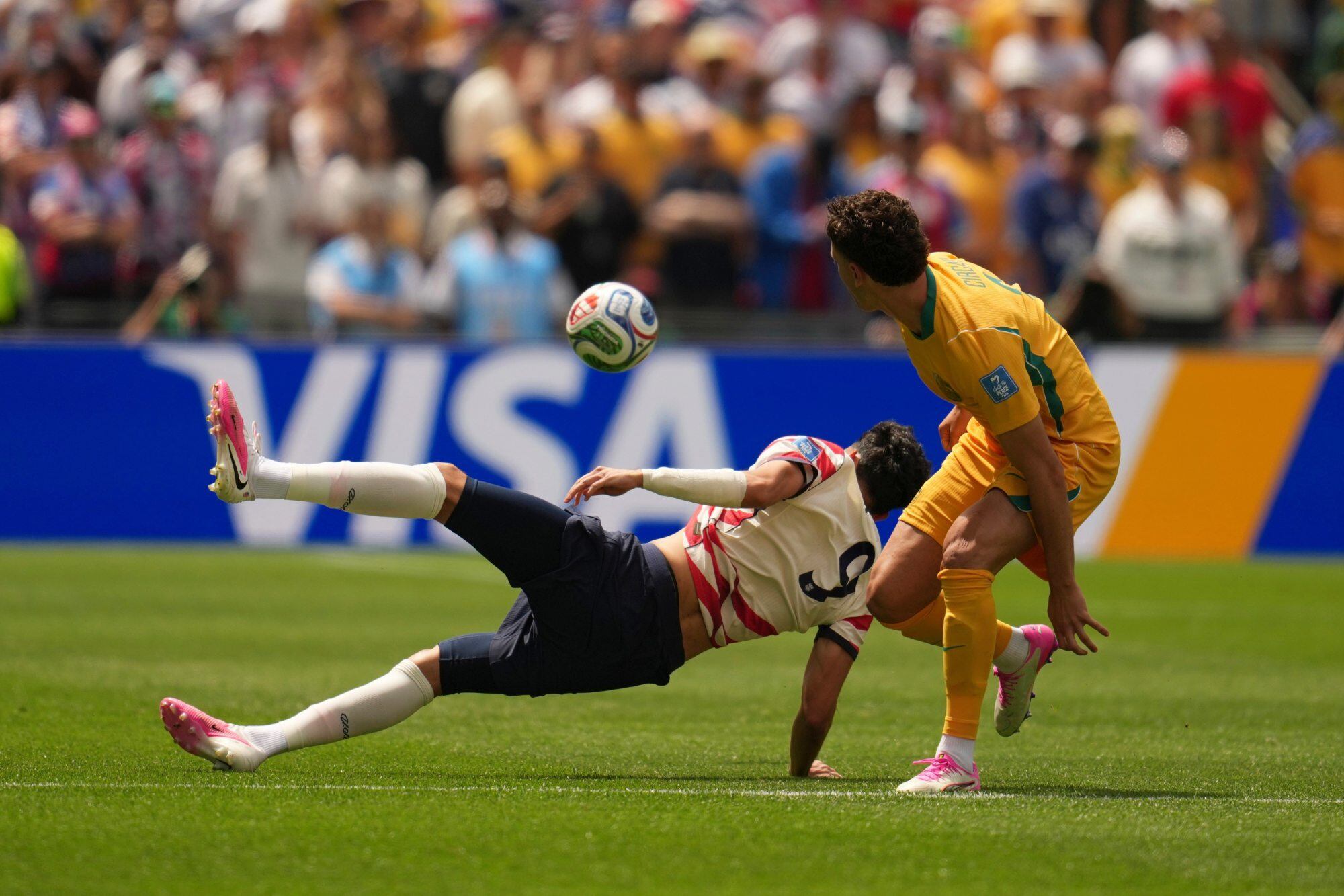 Ricardo Pepi va al piso buscando la pelota y lo marca el australiano Alessio Circati