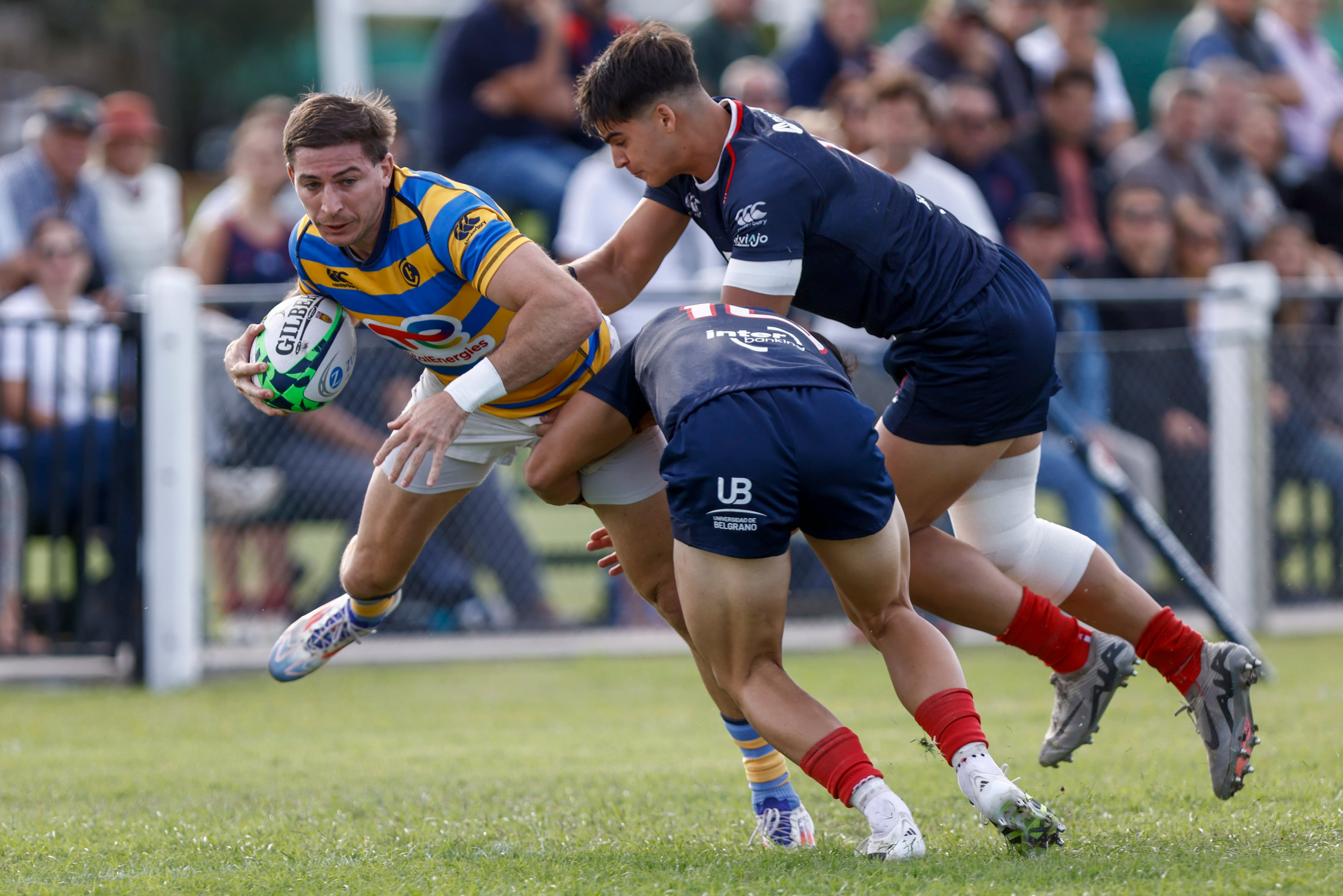 Sebastián Cancelliere es tackleado por Agustín Lamensa, mientras llega Ignacio Bensadón; Hindú es puntero exclusivo en Buenos Aires, al cabo de cuatro jornadas.