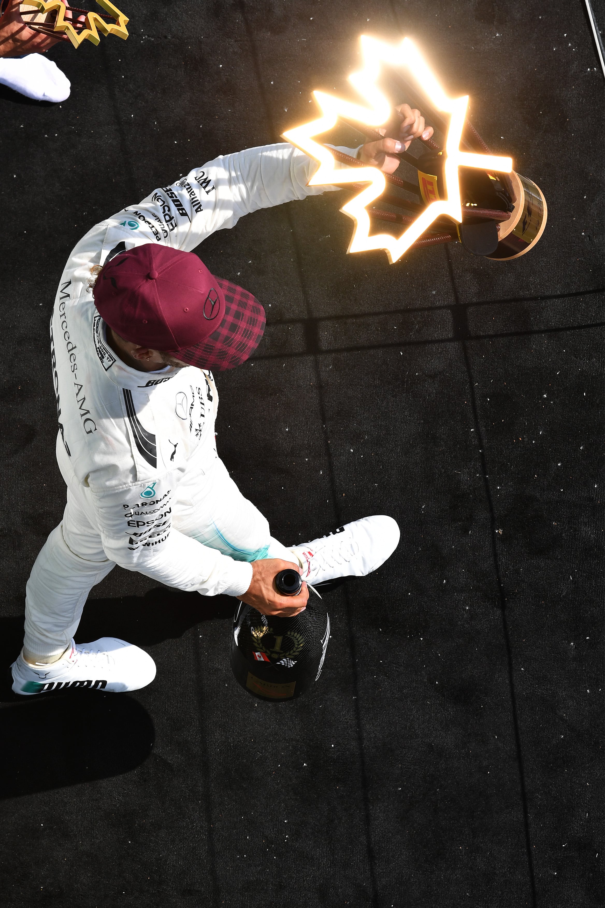 Lewis Hamilton sostiene el trofeo del Gran Premio de Canadá y el sol hace que el premio parezca iluminado desde dentro; Sutton se quedó esperando una situación diferente para fotografiar en el podio, y la consiguió.