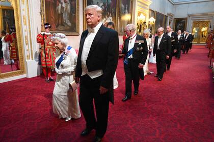  La reina británica Elizabeth II, camina con el presidente de EE. UU. Donald Trump y otros invitados cuando llegan a través de la East Gallery durante un banquete estatal en el salón de baile en el Palacio de Buckingham