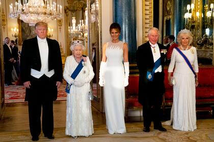 La reina británica Elizabeth II, camina con el presidente de EE. UU. Donald Trump y otros invitados cuando llegan a través de la East Gallery durante un banquete estatal en el salón de baile en el Palacio de Buckingham