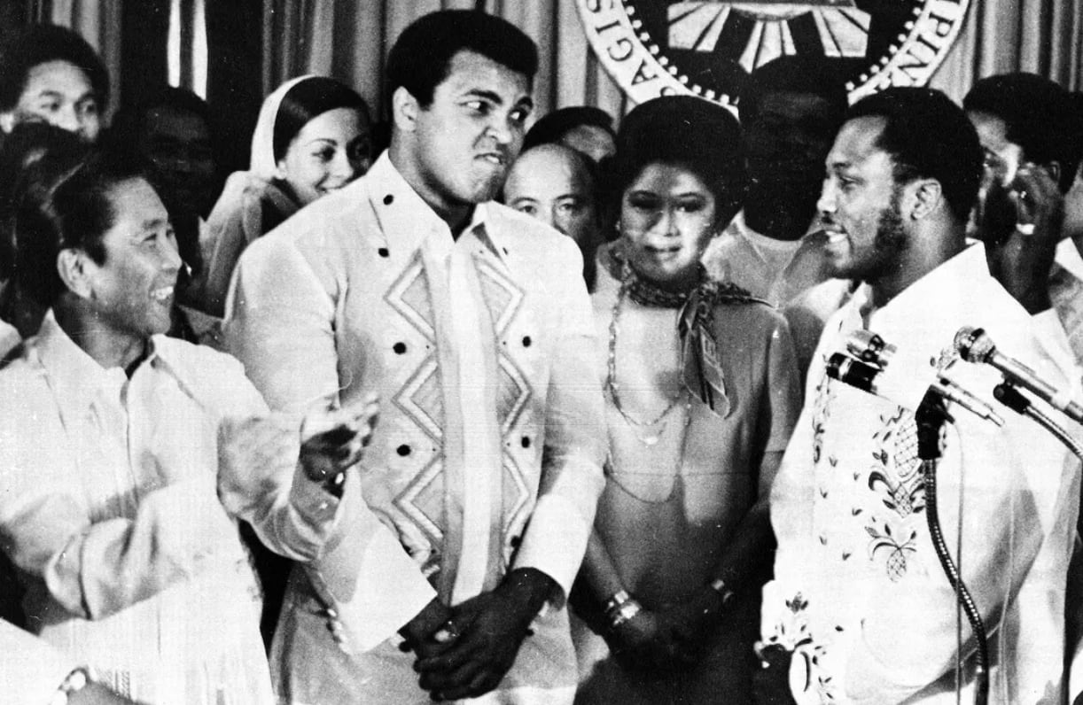 Ferdinand Marcos aplaude a Joe Frazier mientras el boxeador habla de su rival, Muhammad Ali. Ambos visitaron al presidente filipino en el palacio de Malacañang, en Manila, el 18 de septiembre de 1975, días antes de la pelea. Entre ellos aparece Imelda Marcos. (Foto: Jess Tan/AP)