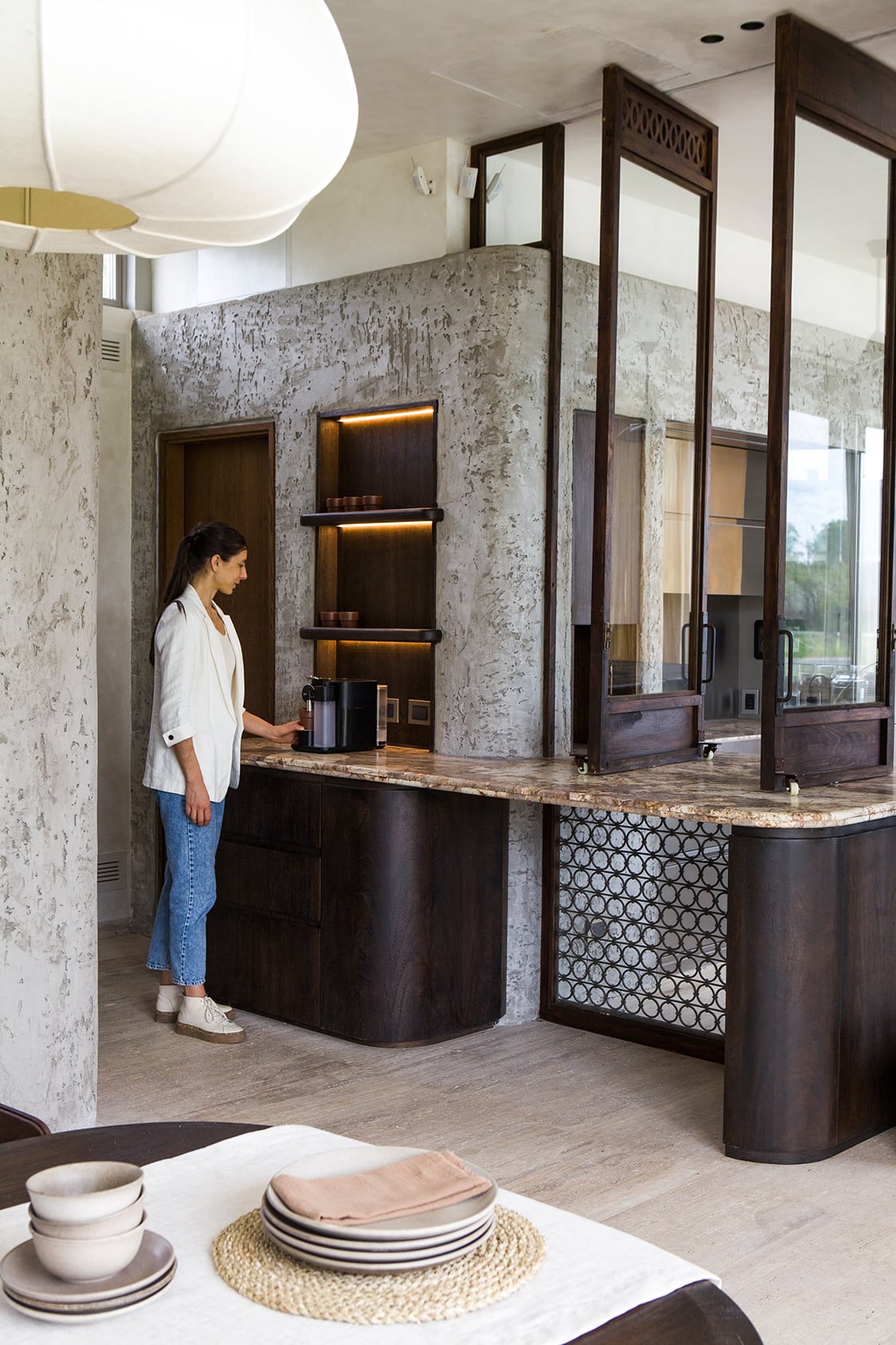 Florencia Cambrea frente a la estación de café, con una mesada que se extiende para abastecer el quincho con solo abrir las ventanas pivotantes.