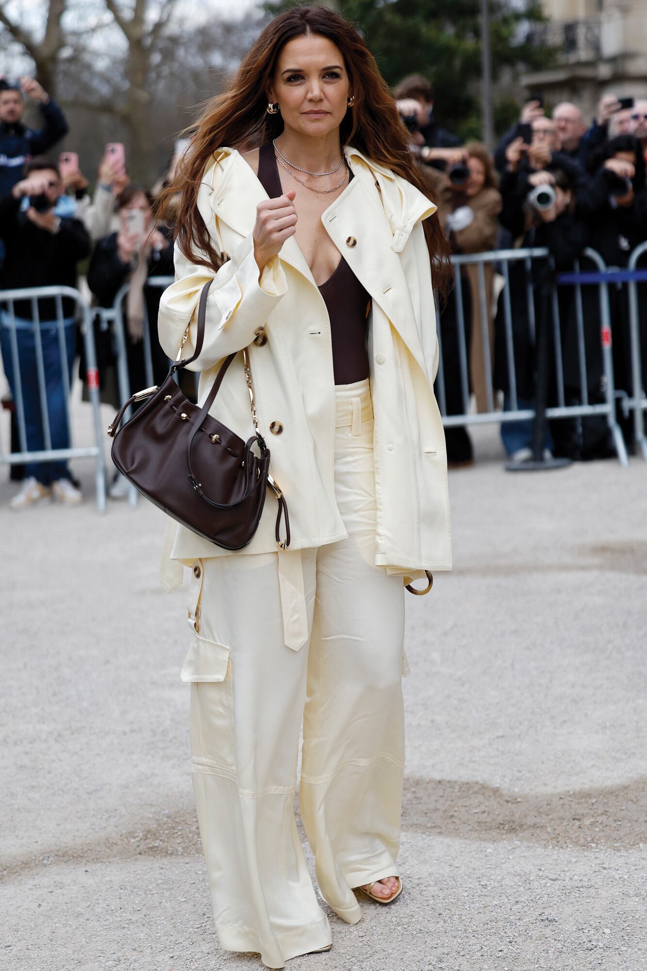 Katie Holmes asistió al desfile de Zimmermann con un conjunto de esa marca: chaqueta y pantalones cargo en color manteca sobre un escotado body negro, y cartera marrón.