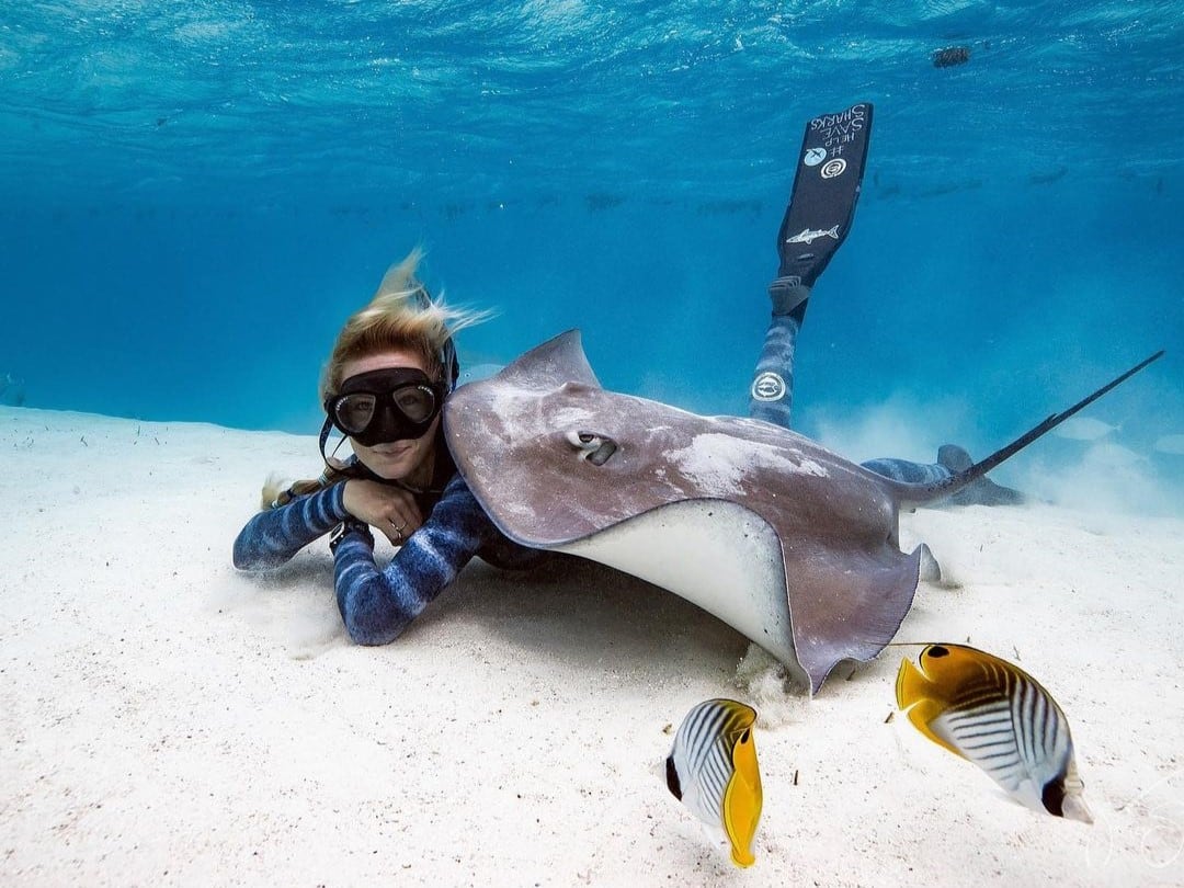 La bióloga marina hawaiana de 38 años, Ocean Ramsey, posando junto a una raya