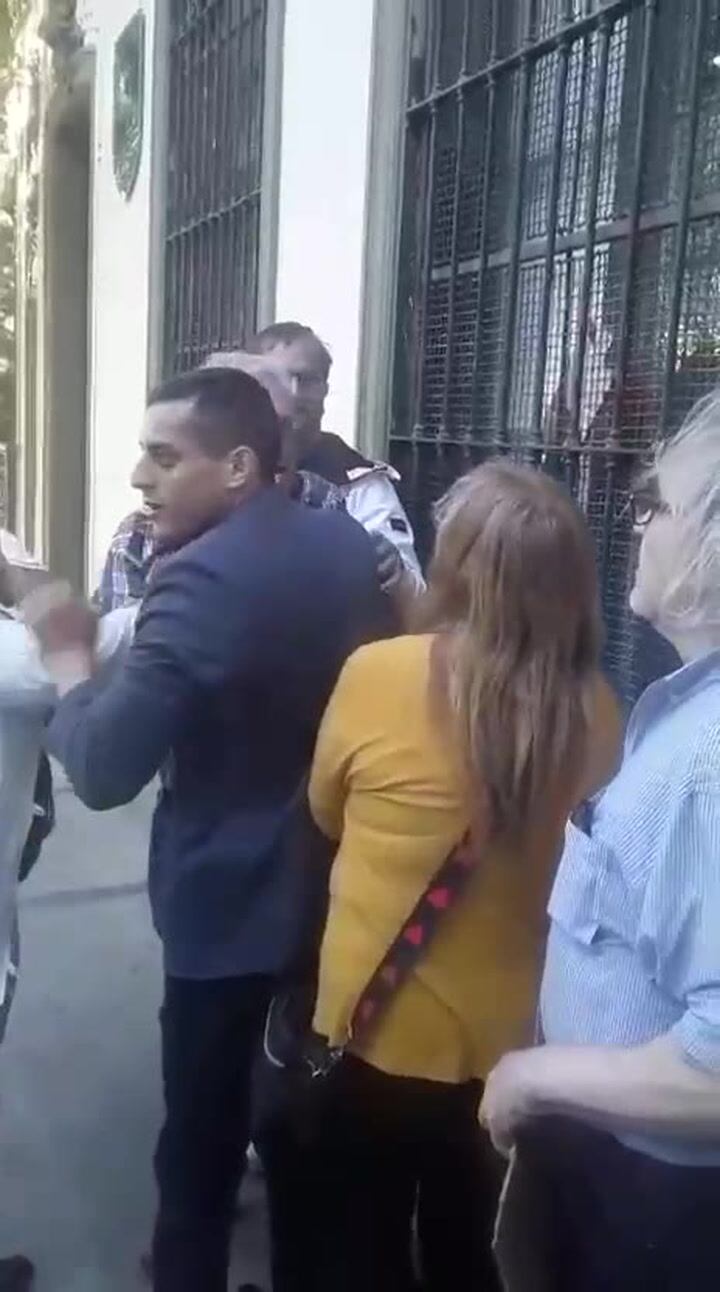 El agresor está tapado por el hombre de saco azul, que intenta evitar el ataque (captura de pantalla)