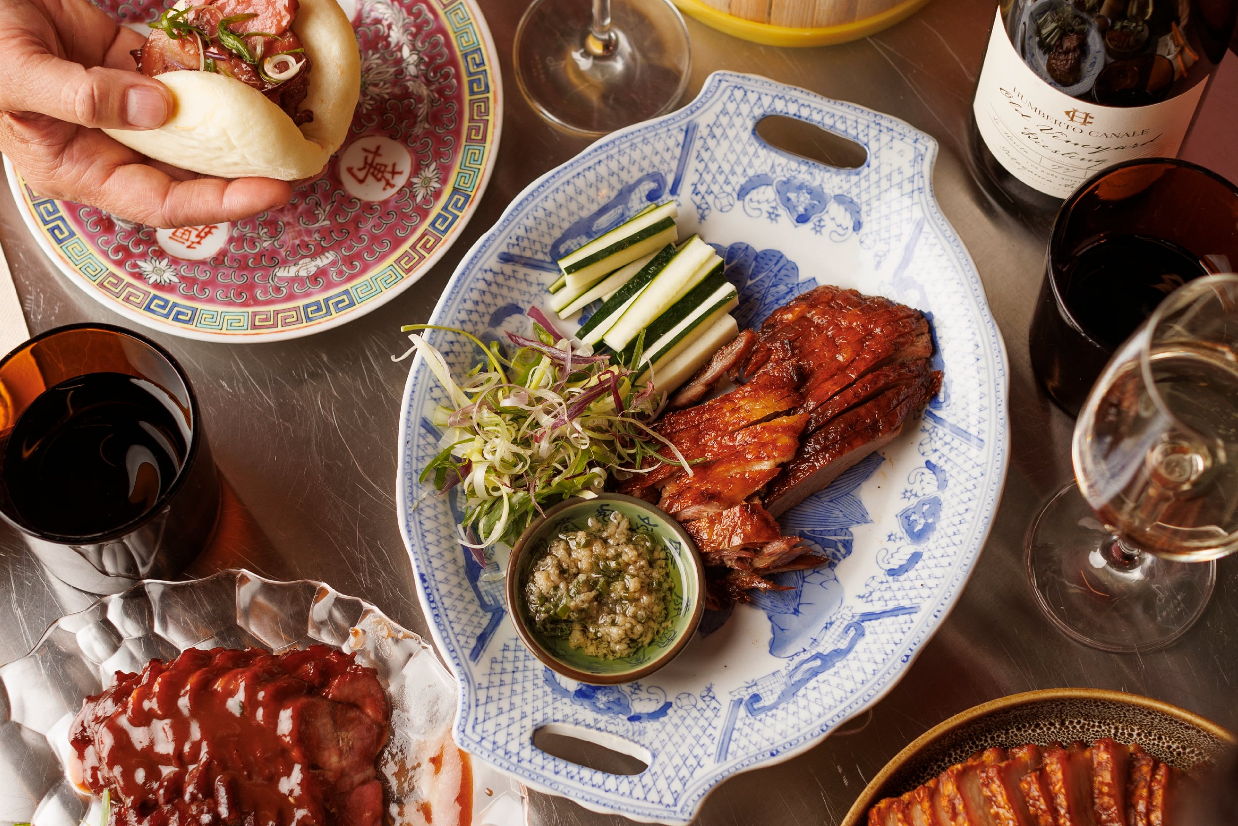 El cerdo laqueado se sirve al plato y viene con baos (pancitos al vapor) para rellenar con salsitas y pickles.