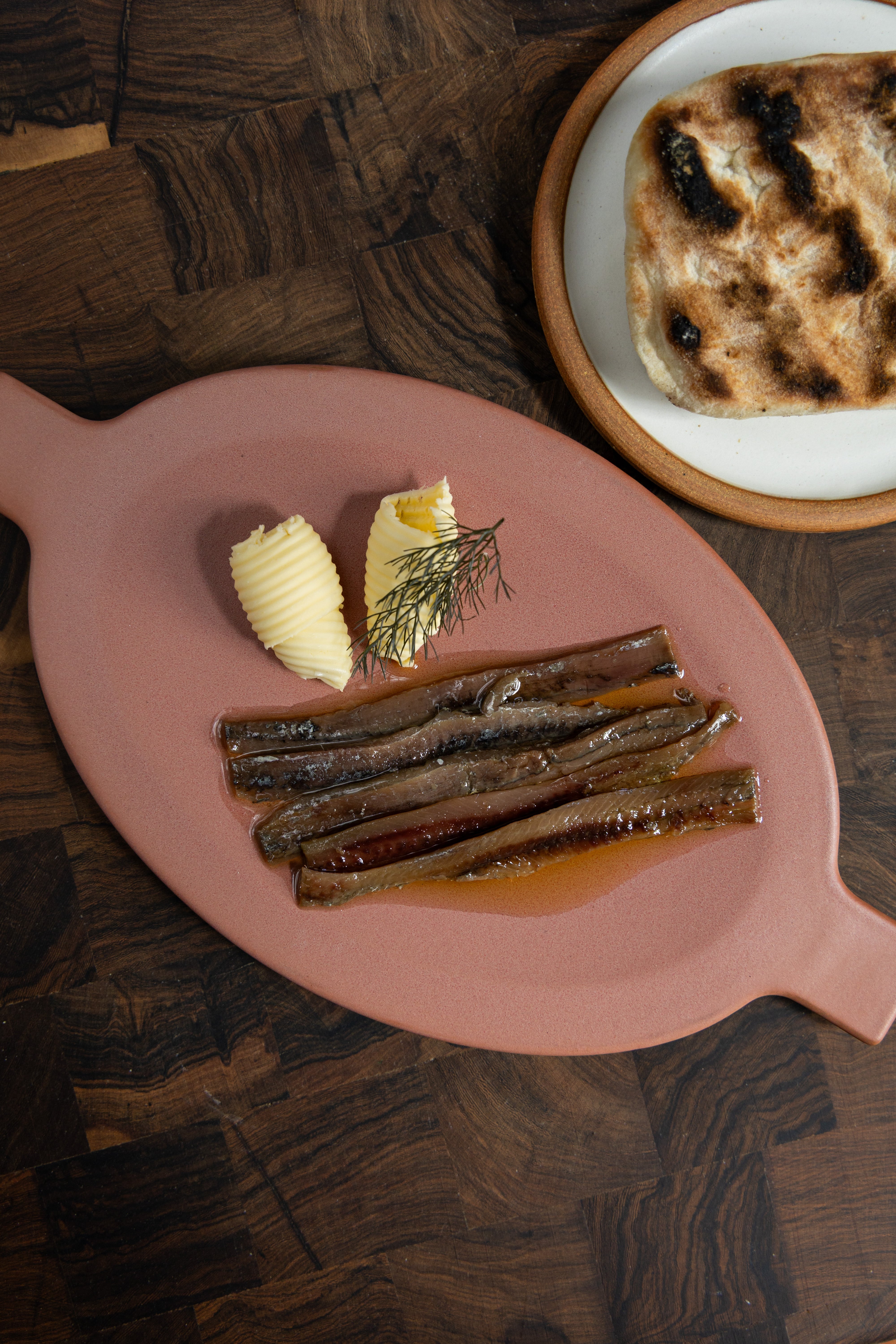 Anchoas artesanales conservadas en aceite de oliva, pan casero terminado a la brasa y manteca Lobos