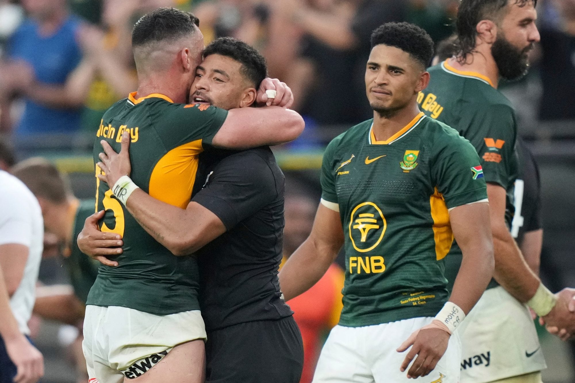 Jesse Kriel se abraza con el regresado y aclamado Richie Mo'unga, ante Sacha Feinberg-Mngomezulu; los jugadores de ambos equipos terminaron orando juntos tras el partido.