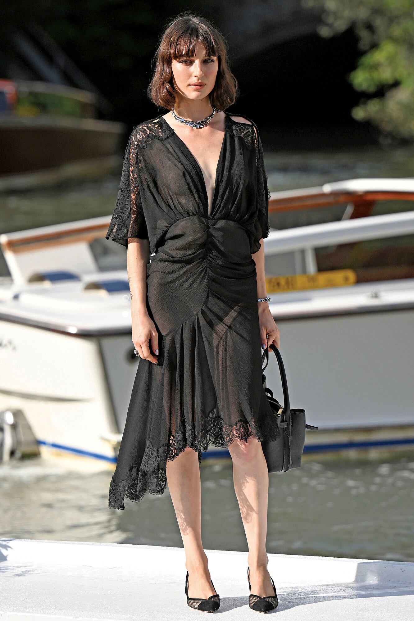 Durante la tercera jornada, la actriz italiana Alice Pagani posa en el muelle del Hotel Excelsior Venice Lido con un vestido de inspiración romántica firmado por John Galliano y alhajas de Giovanni Raspini
