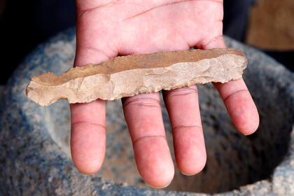 Un arqueólogo muestra un cuchillo de sílex, desenterrado en la ciudadela