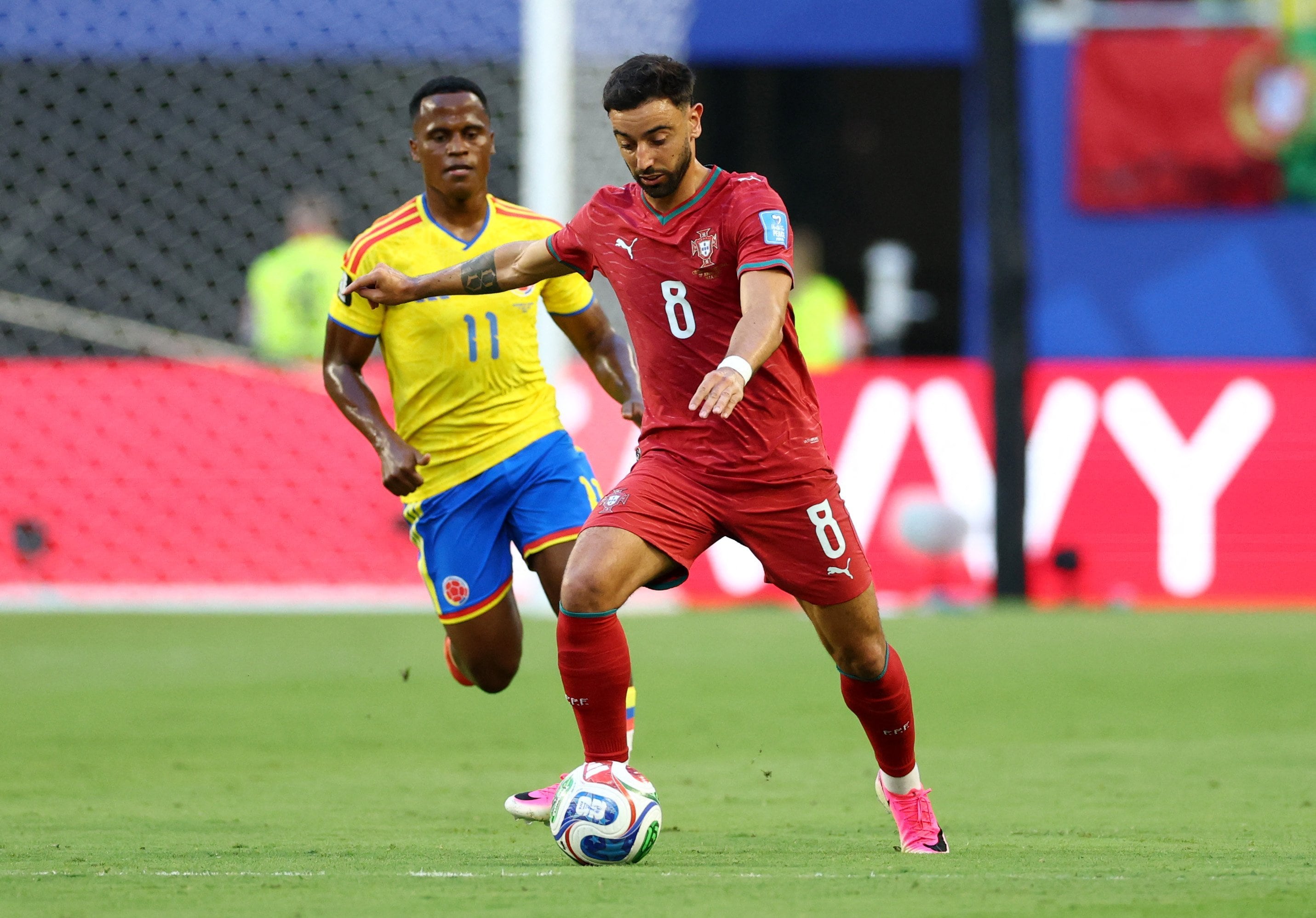 El portugués Bruno Fernandes lleva la pelota ante la marca distante del colombiano Jhon Arias