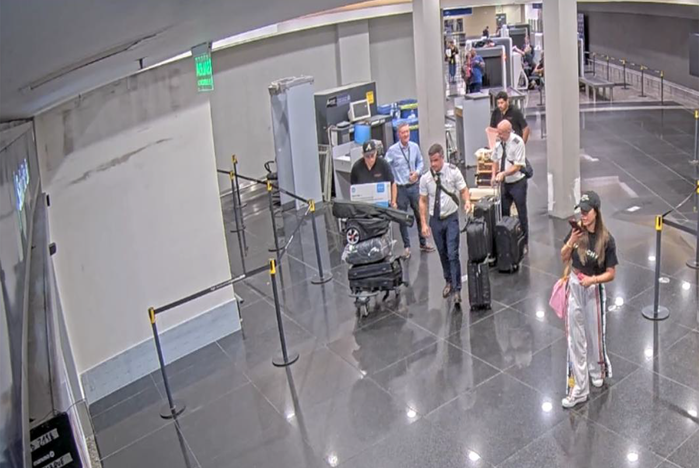 Belén Arrieta, tras pasar los escáneres de Aeroparque, detrás parte de la tripulación con las valijas.