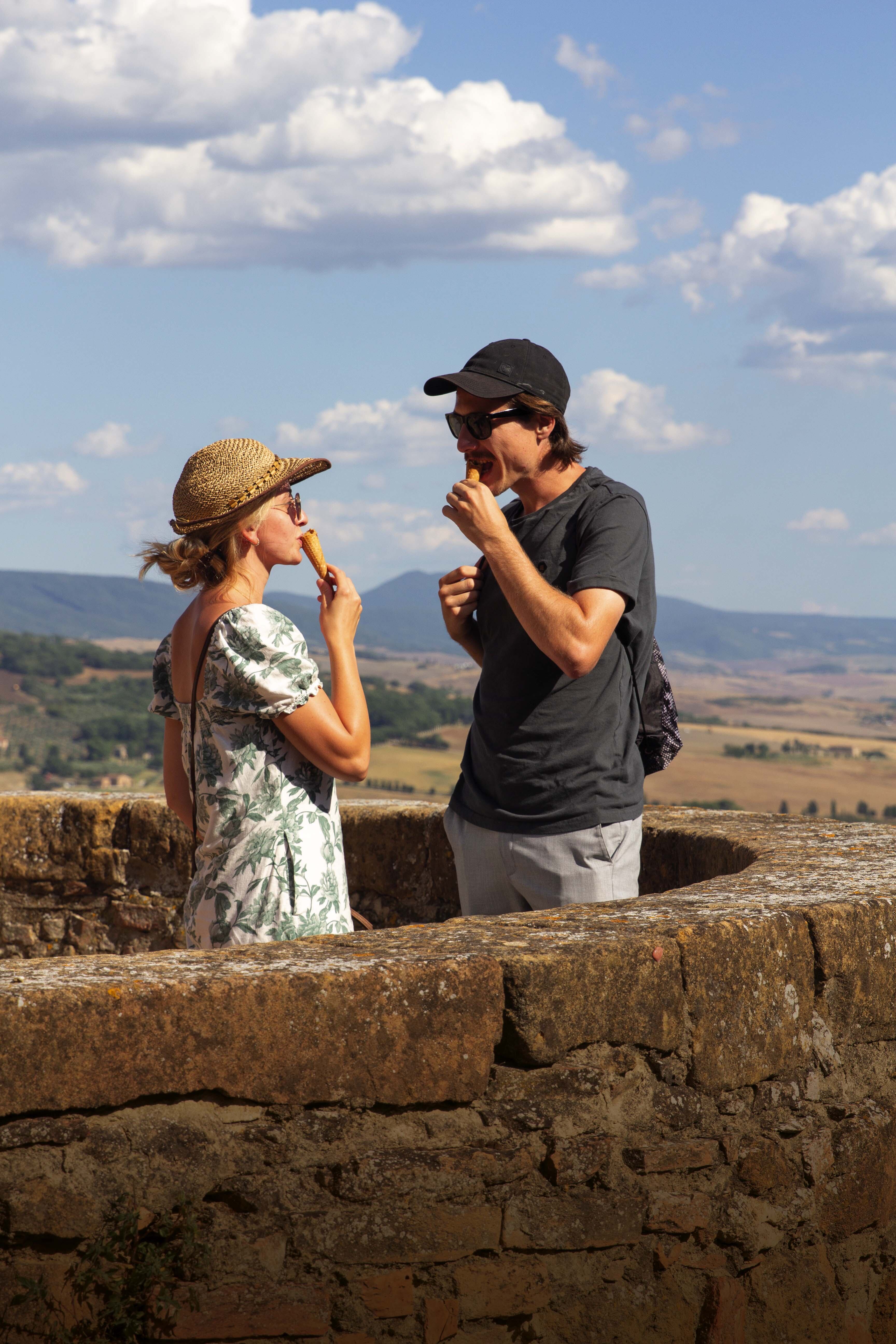 Una pareja de turistas alemanes toma un gelatto en el mirador de Pienza.