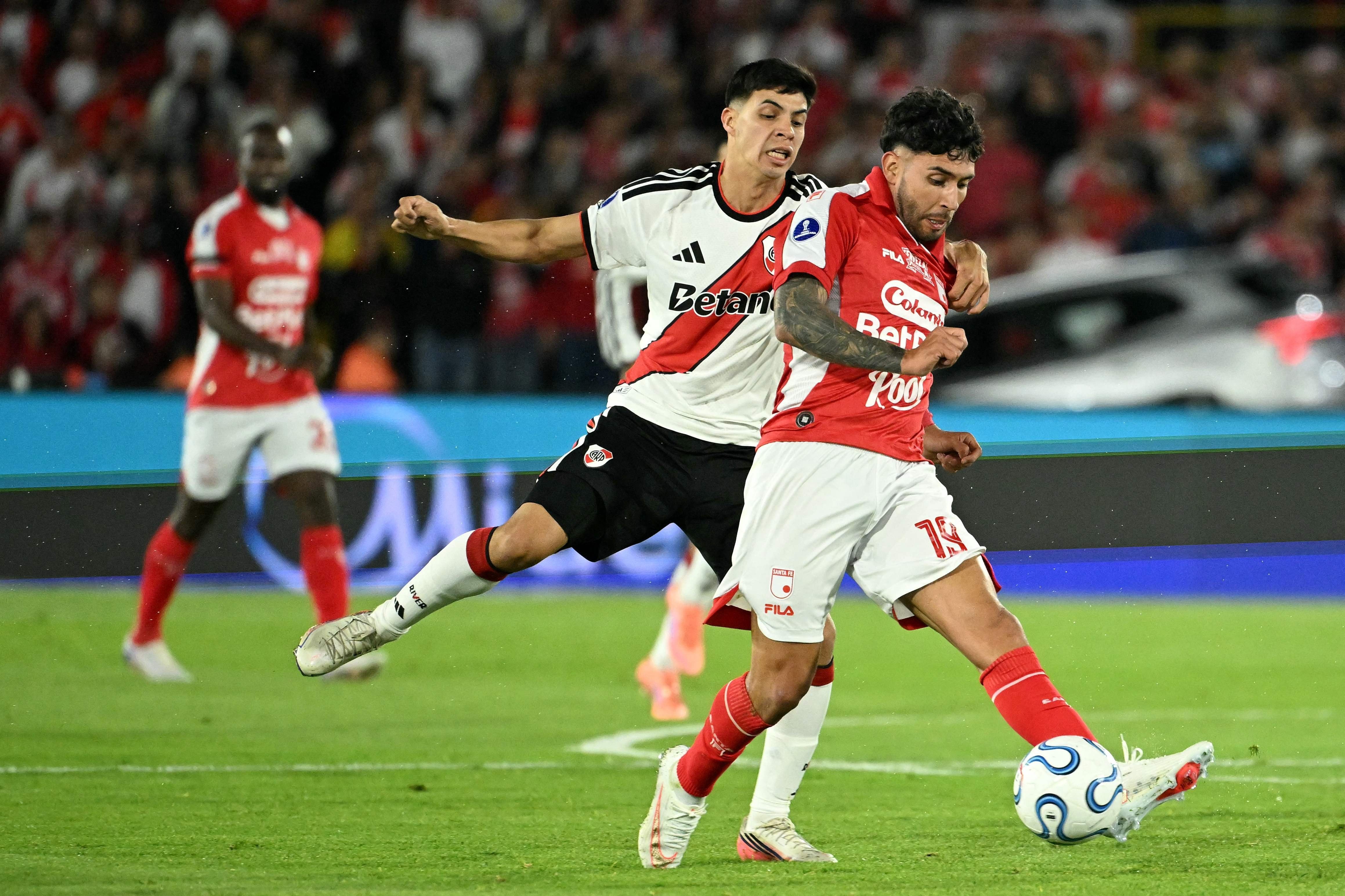 Tomás Galván agarra a Nahuel Bustos, que lleva la pelota