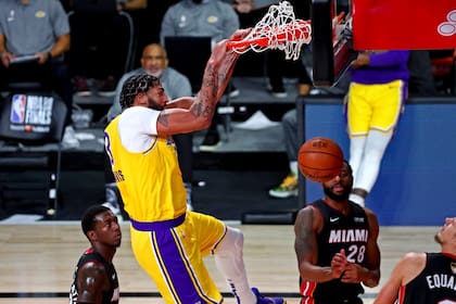6 de octubre de 2020; Miami, Florida, Estados Unidos; El alero de Los Angeles Lakers Anthony Davis (3) clava el balón contra el escolta de Miami Heat Andre Iguodala (28) durante el segundo cuarto del juego 4 de las Finales de la NBA 2020 en AdventHealth Arena.