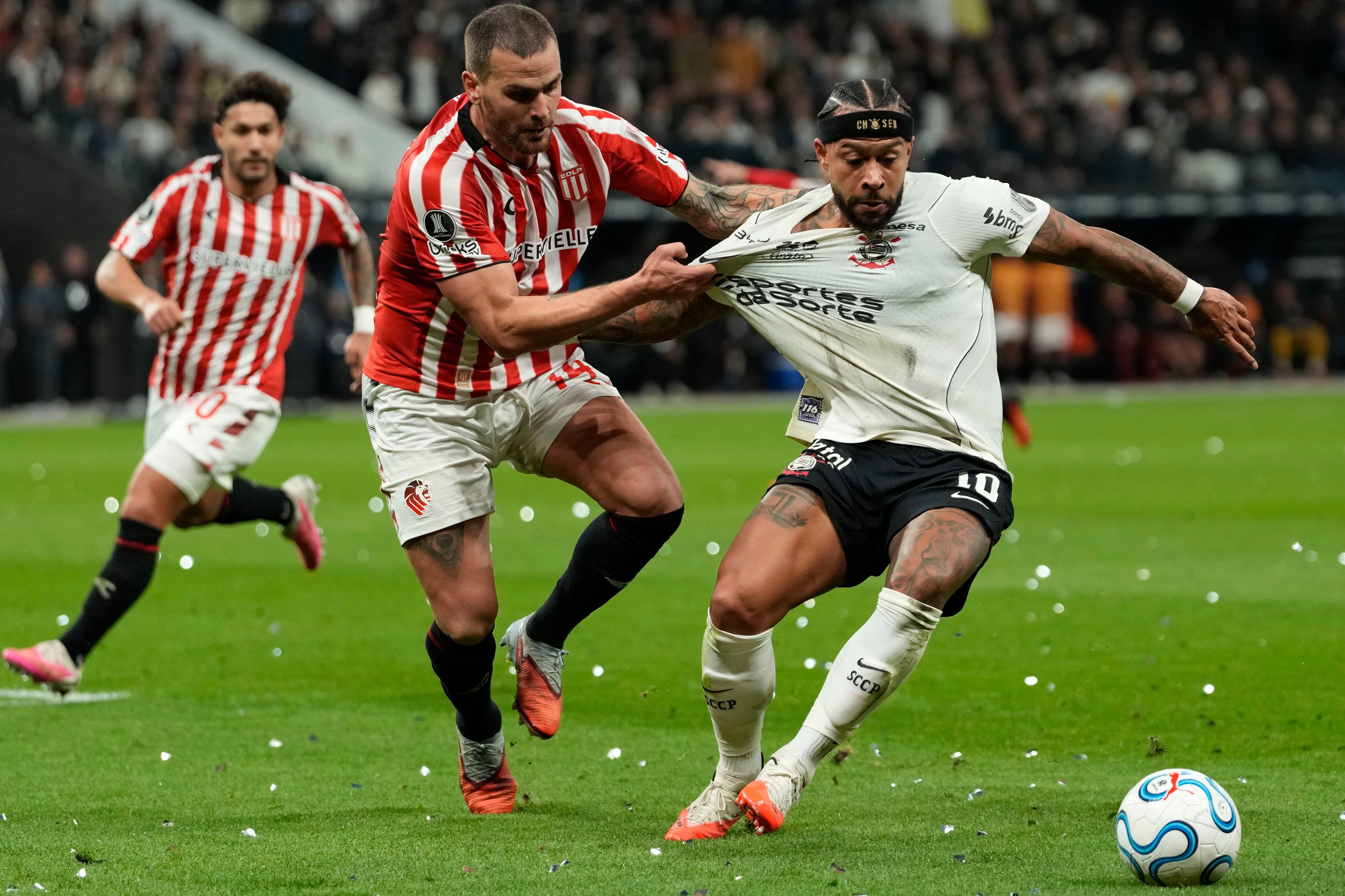 Leandro González Pírez toma de la camiseta a Memphis Depay: el zaguero de Estudiantes cometió la infracción para el penal que malogró el delantero neerlandés en el descuento