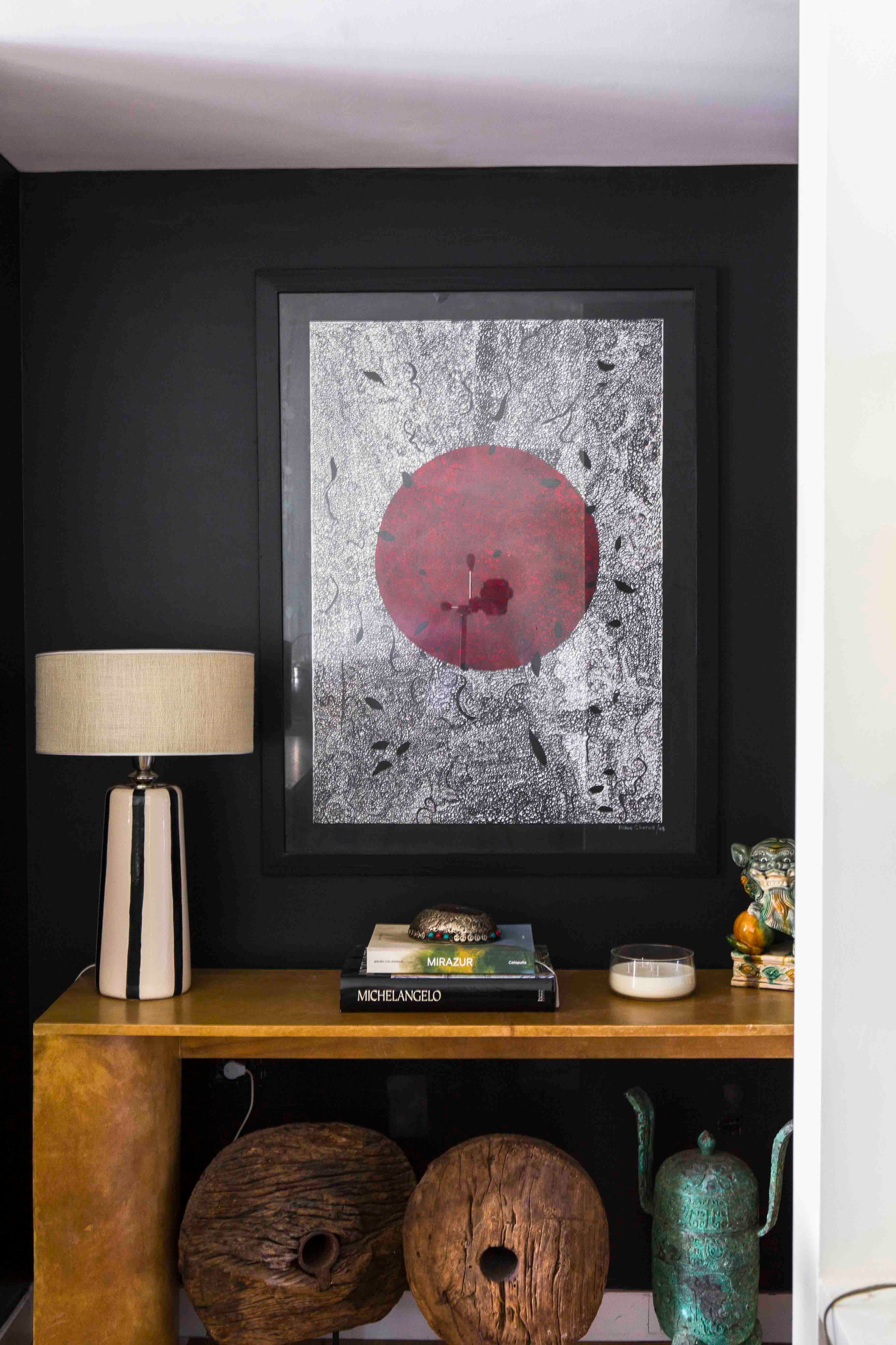 En la entrada, consola (Harturo), obra de arte (Diderot. art) sobre un color negro profundo (Colorín).