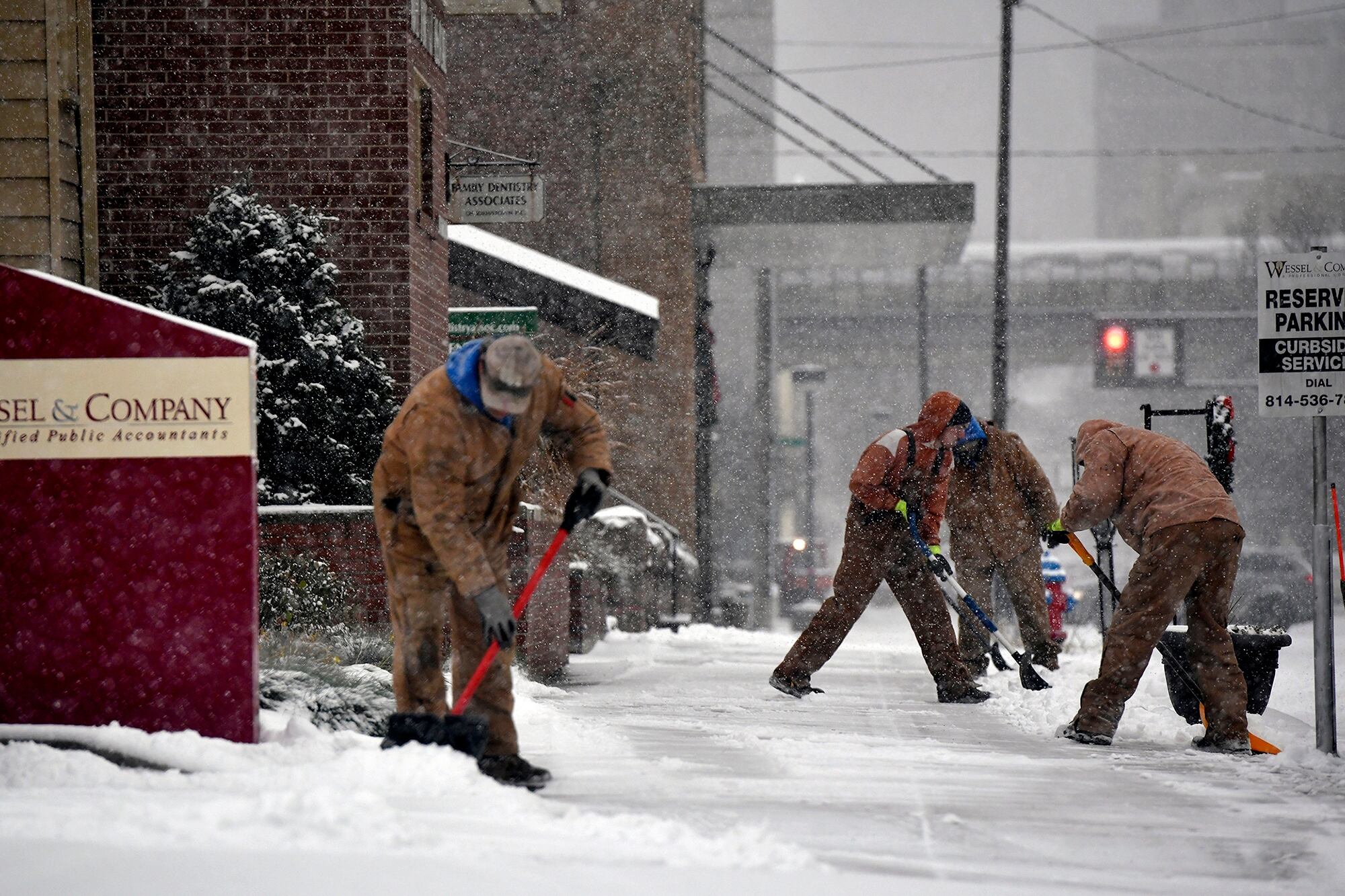 Trabajadores remueven la nieve de las veredas en Johnston, Pensilvania