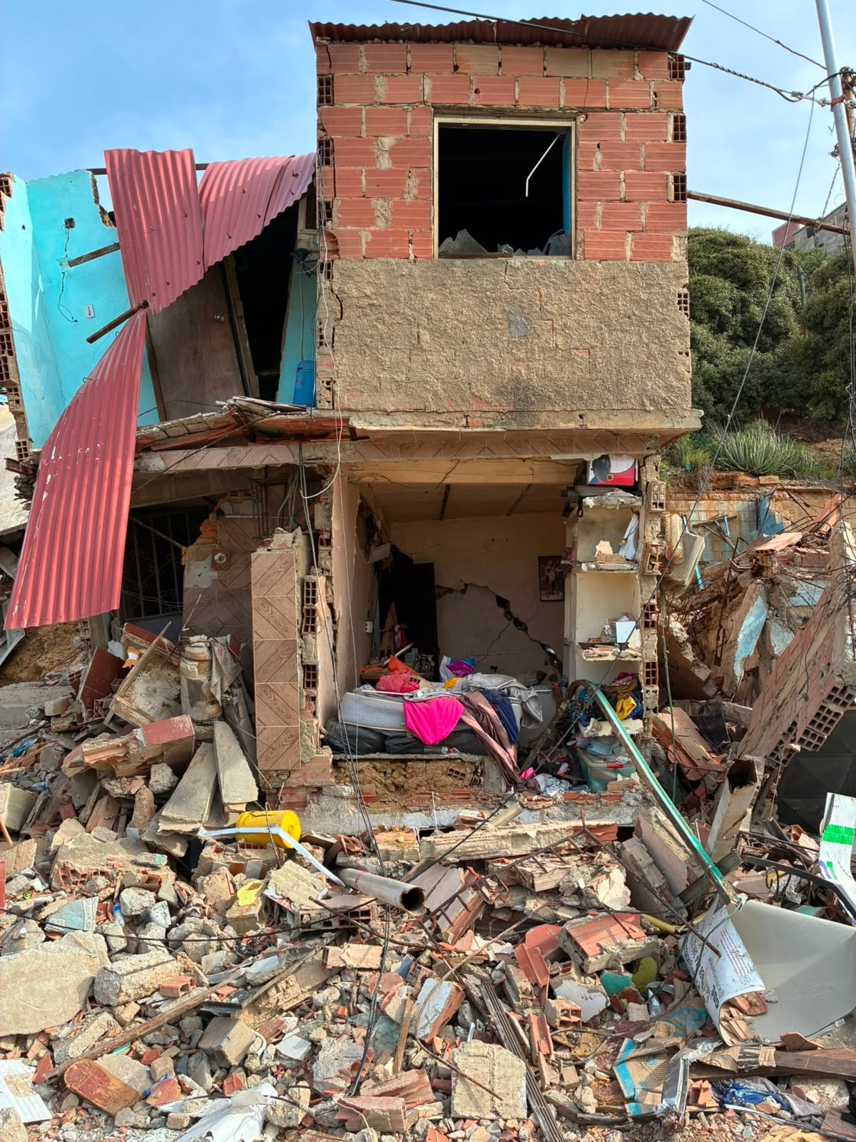 Una habitación expuesta sin pared en medio de la vivienda desmoronada