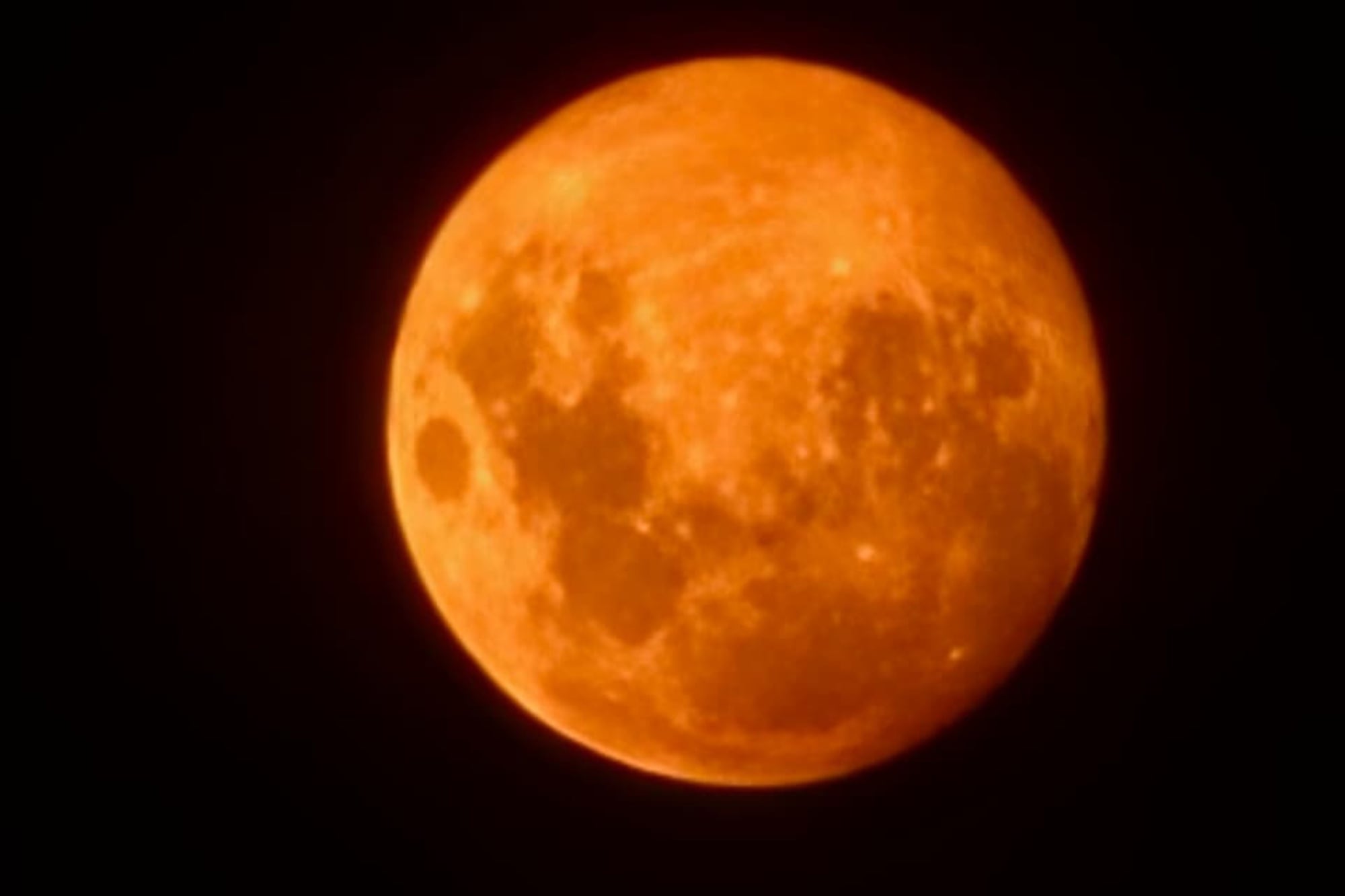 Una luna anaranjada y difusa, consecuencia de la densa concentración de humo en el aire