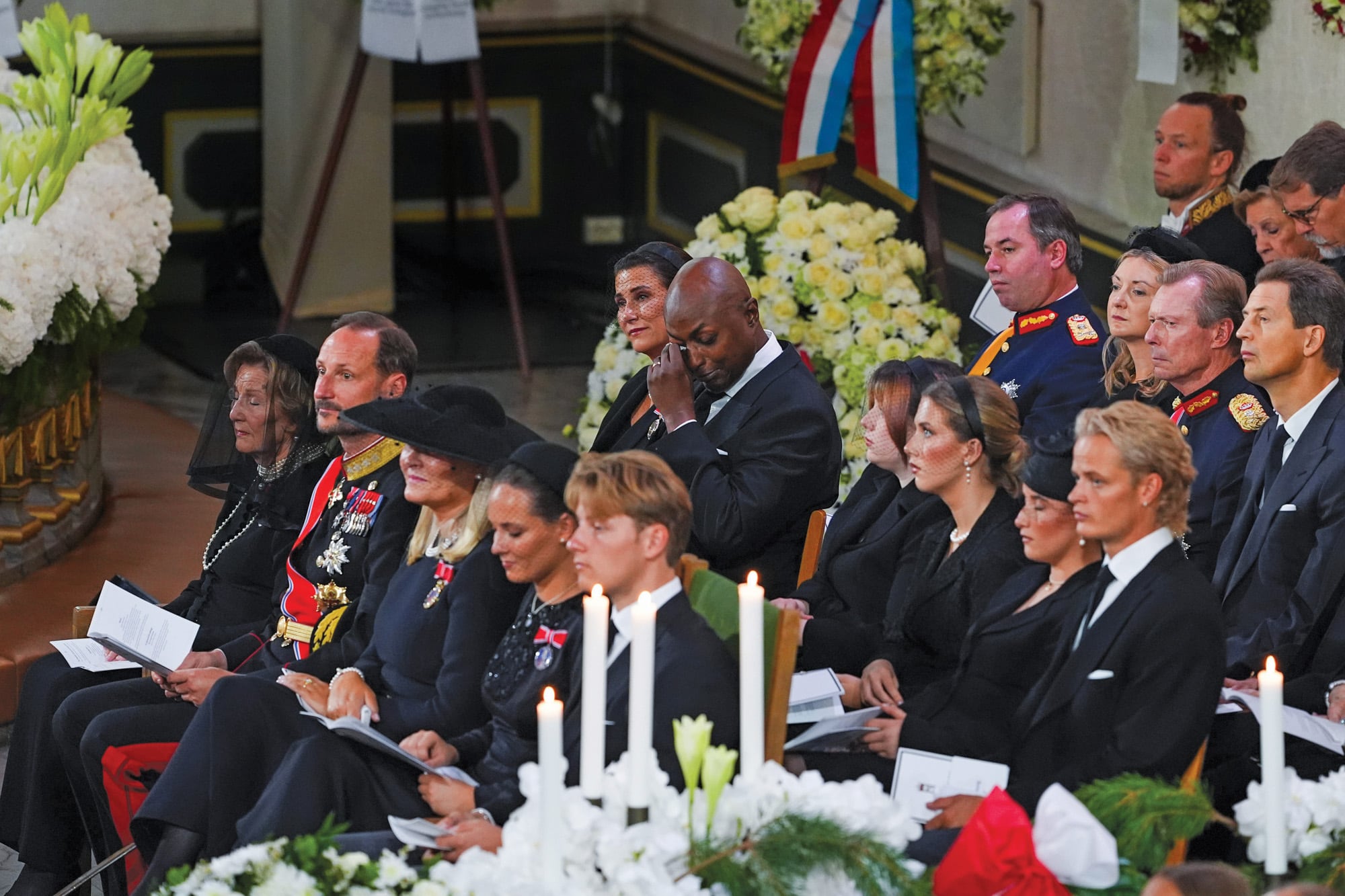 En primera fila, de izquierda a derecha, la reina Sonia, el rey Haakon, Mette-Marit, Ingrid, Sverre Magnus. En segunda fila: la princesa Marta Luisa y su marido, Durek llorando, las tres hijas de Marta Luisa y Marius Borg