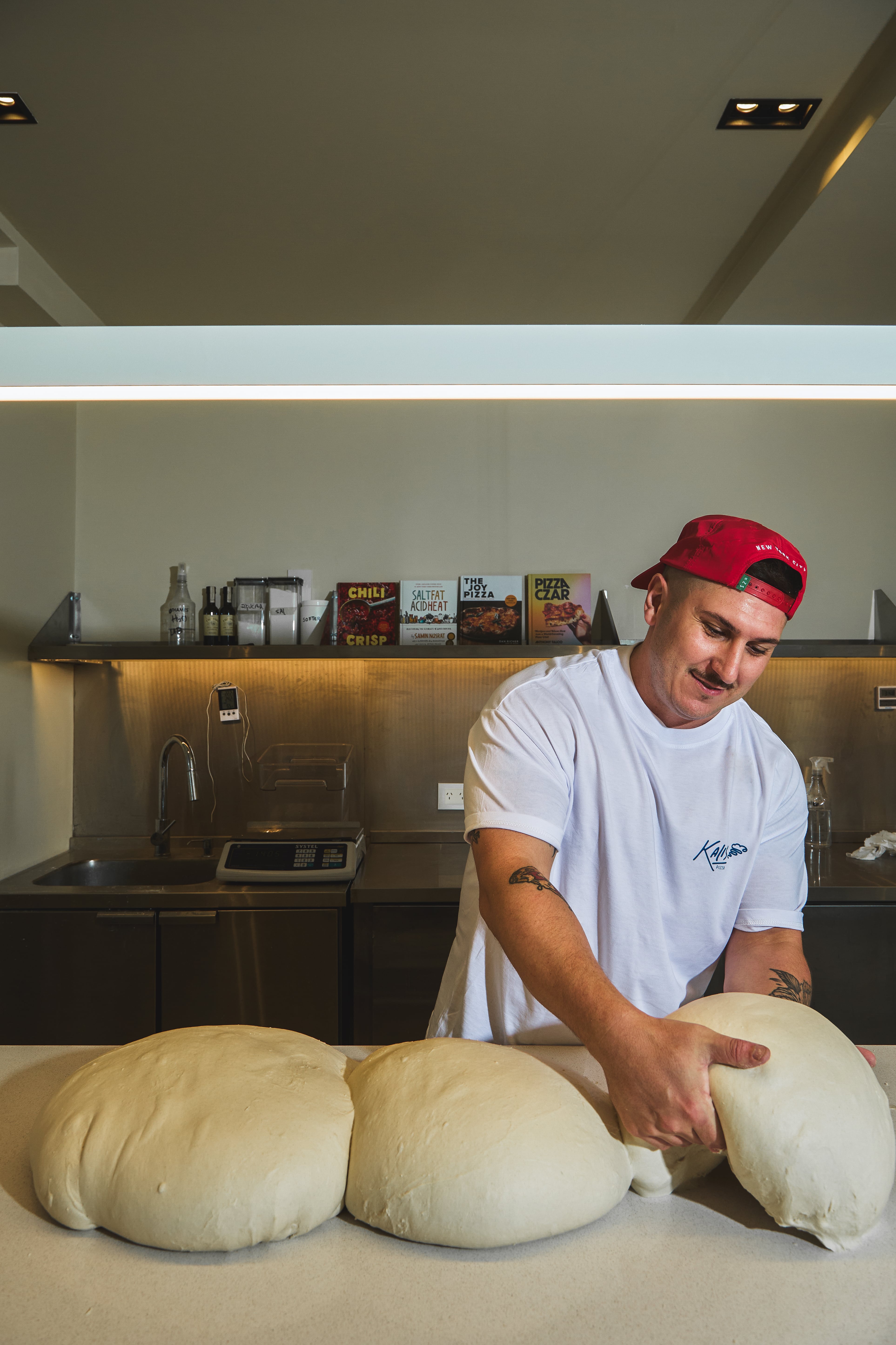 La pizza finita, crocante y jugosa de solo cuatro variedades que genera largas filas en Núñez 6 Franco Kalifon con los boyos de sus pizzas