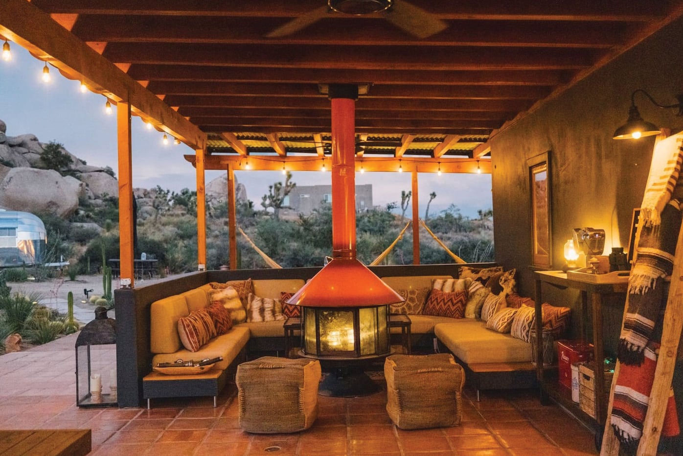 Una galería con un sillón en forma de “U” y una chimenea Malm Imperial Carousel como punto de encuentro. La propiedad también cuenta con un moderno autocine y camas exteriores para descansar en la tranquilidad del desierto