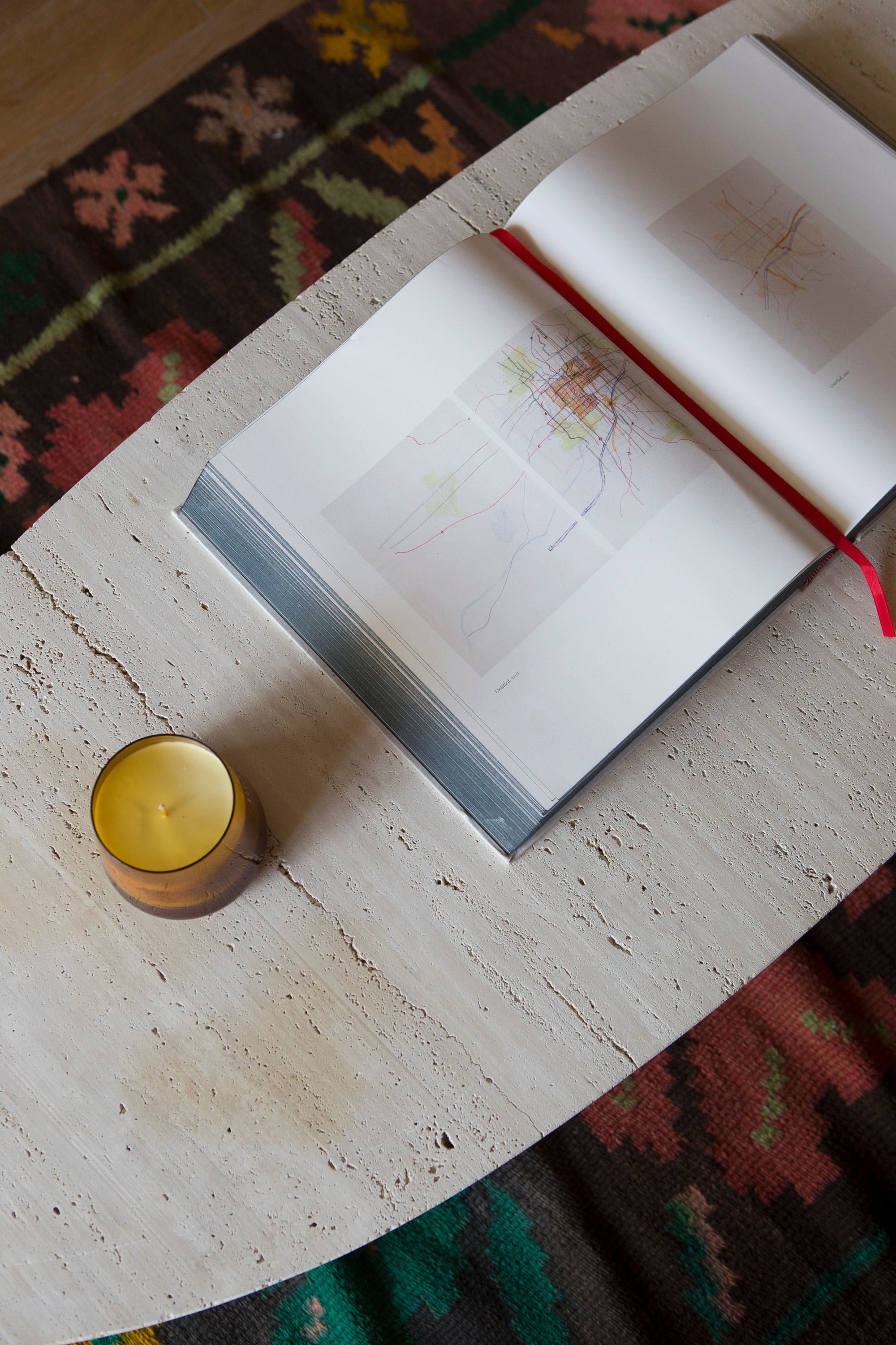 En una doble capa de texturas, alfombra tejida y mesa ovalada de piedra.