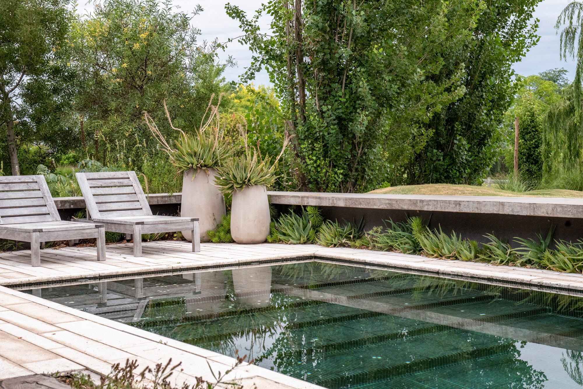 Piedra, hormigón o madera: el borde define el carácter del agua y su relación con el entorno