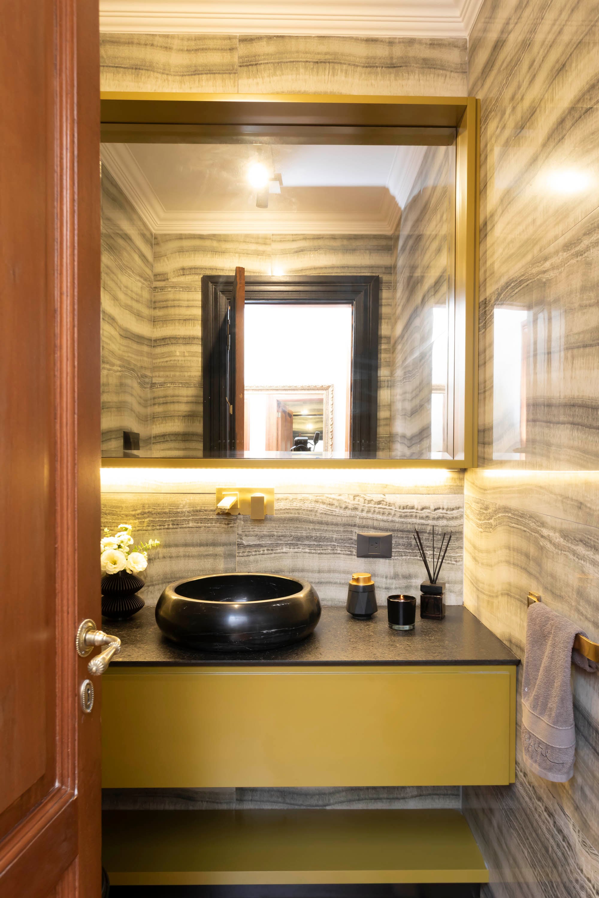 Originalmente ambientado en dorado y mármol, el toilette se actualizó con este moderno espejo encajonado.