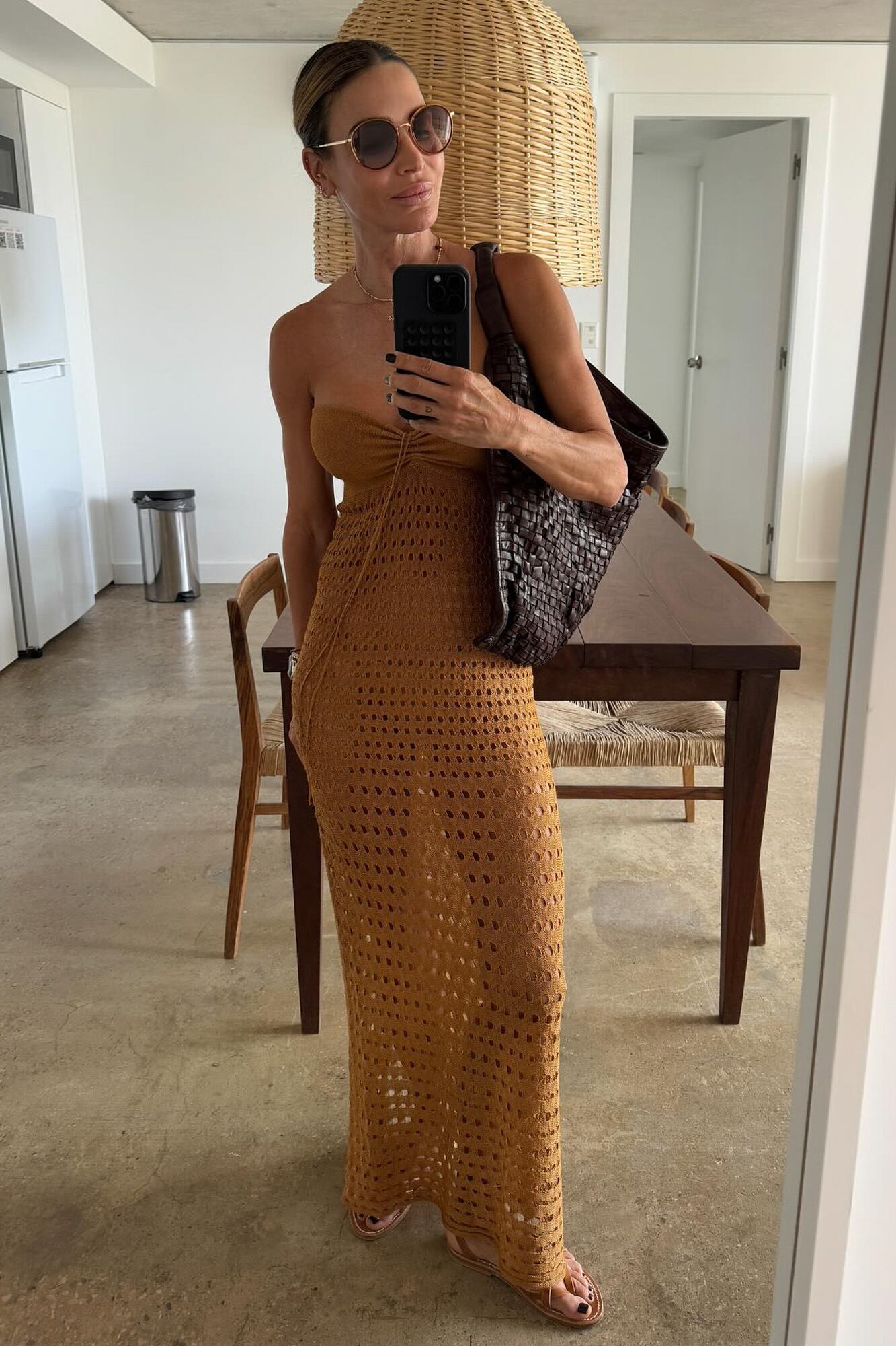 María Vázquez con un vestido strapless de hilo tejido, lista para la playa. Accesorió con un bolso de cuero trenzado y sandalias bajas.