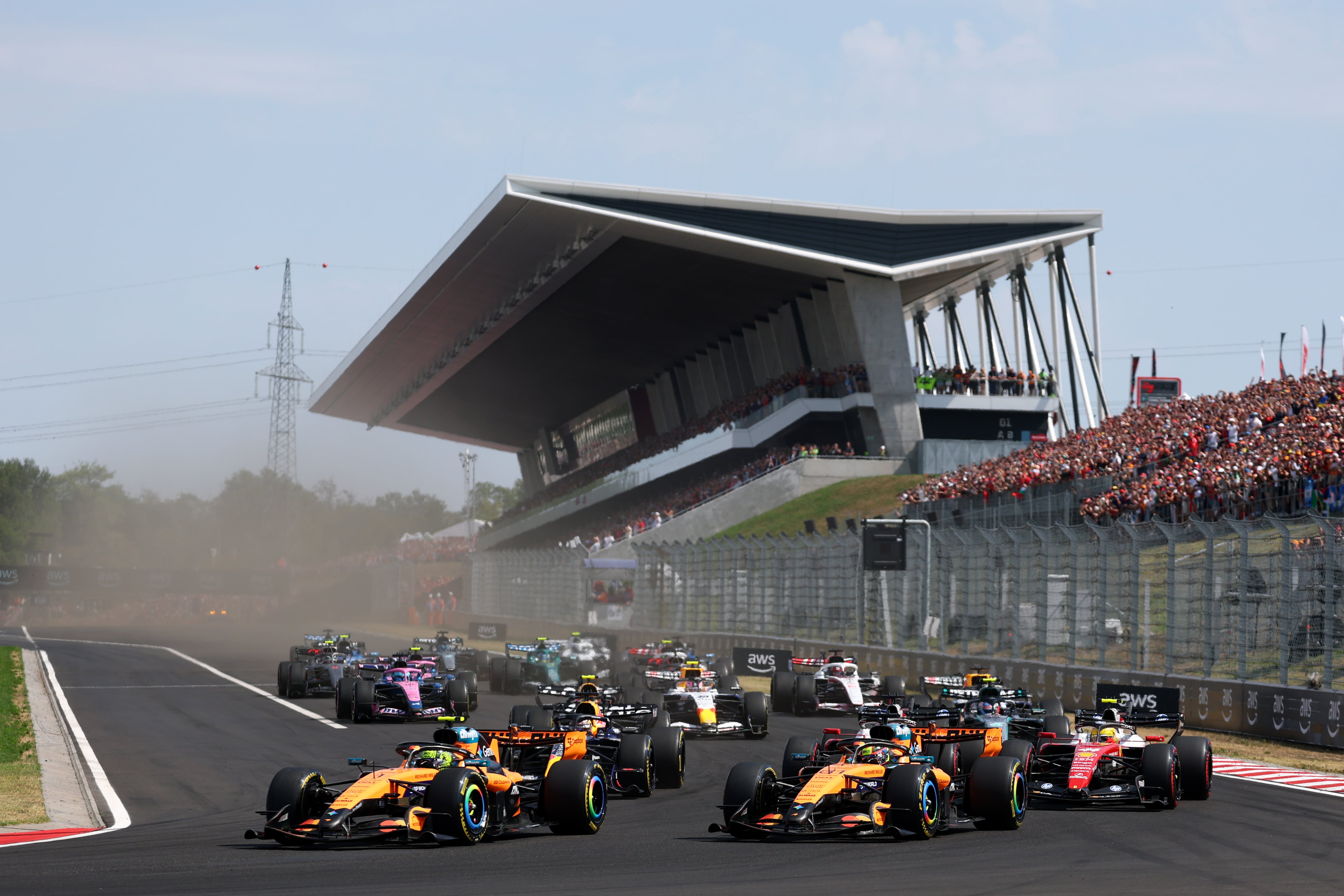 Lando Norris lidera el pelotón en la primera curva del circuito Hungaroring; en la siguiente variante perdería la cabeza de la carrera con su compañero Oscar Piastri