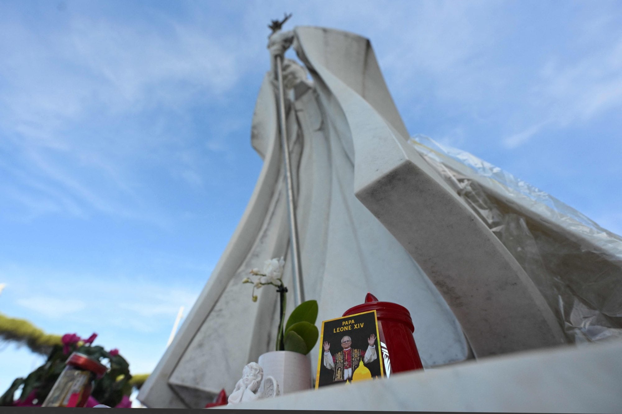 Una imagen del Papa León XIV se encuentra junto a la estatua de Juan Pablo II, en el exterior del Hospital Universitario Gemelli, donde el Papa León XIV se recupera tras la operación