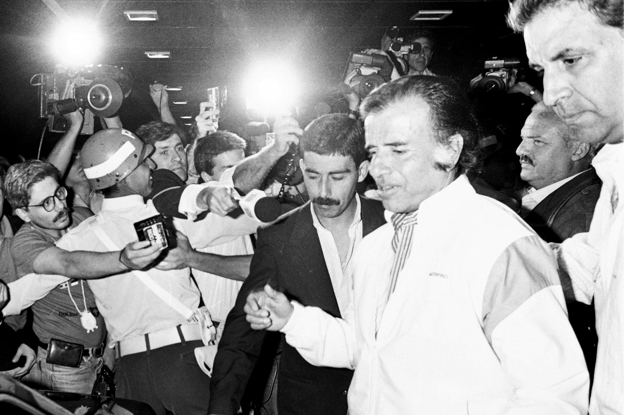 El presidente Carlos Saúl Menem llega al aeroparque tras un viaje a Santa Cruz el 29 de diciembre de 1990, tras firmar los decretos del indulto; detrás, lo acompaña su vocero, Fernando Niembro