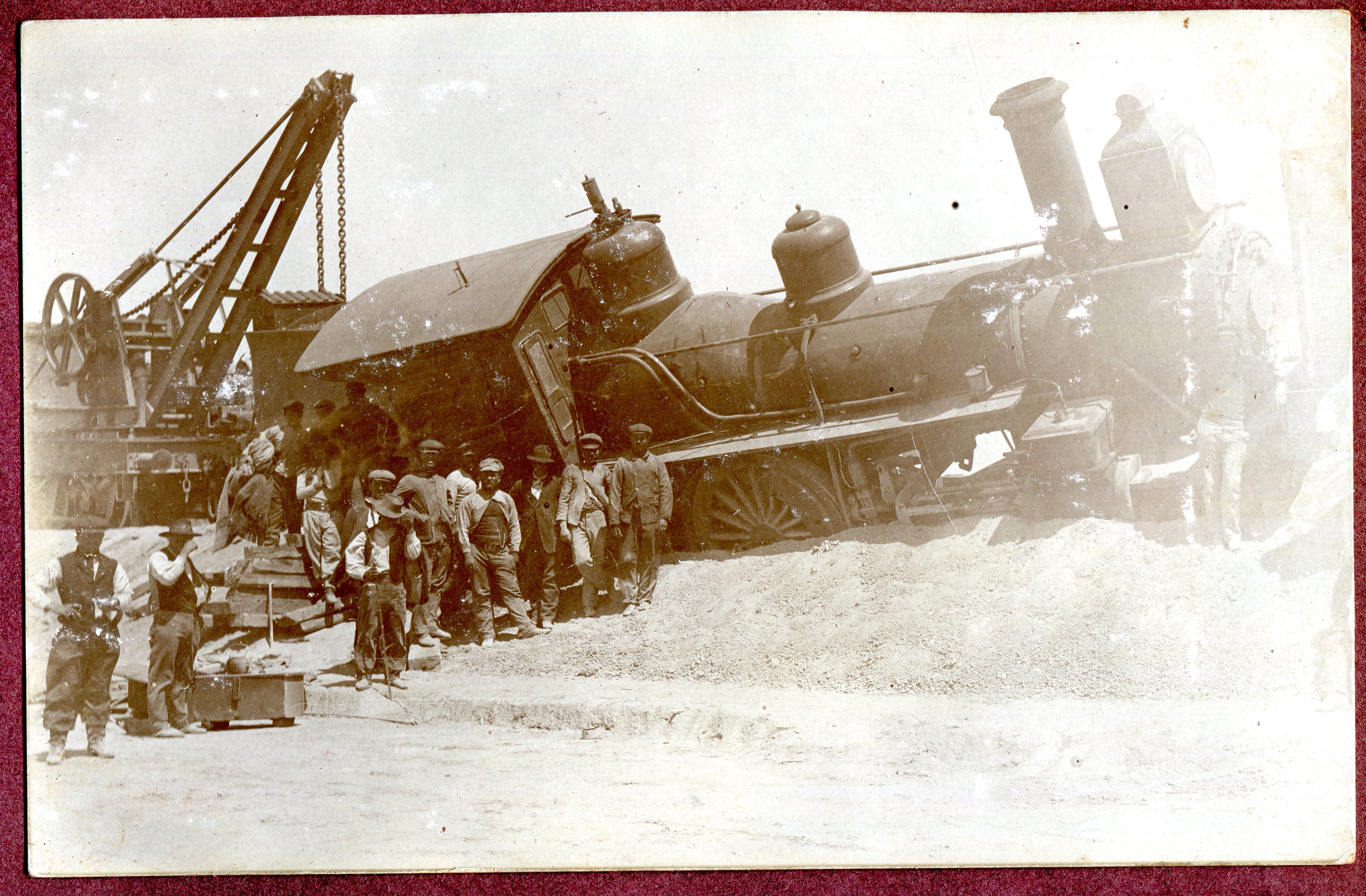 Una locomotora descarrilada y el guinche que intentará ubicarla nuevamente en su huella de acero.