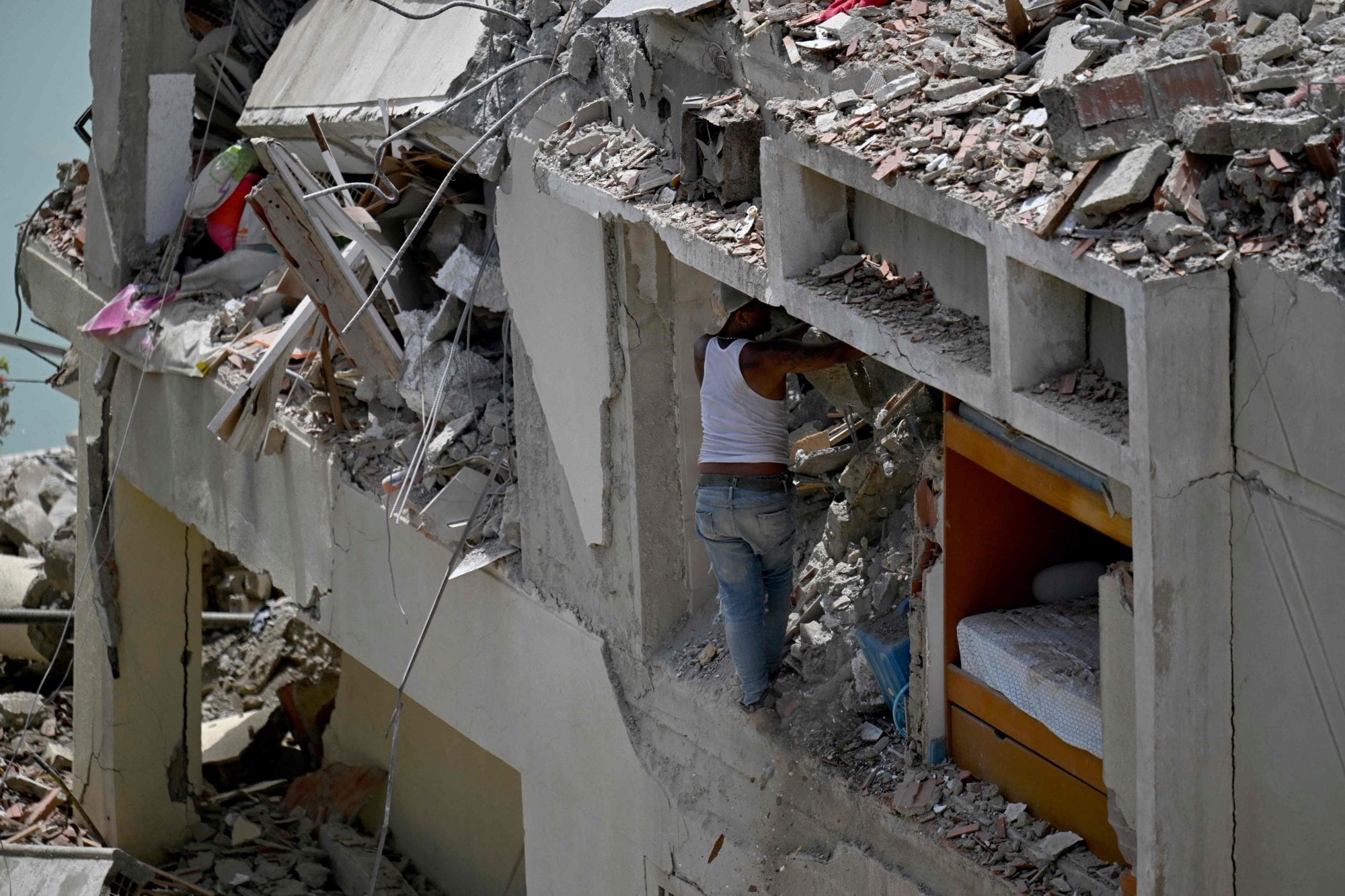 Un hombre rebusca entre los escombros de un edificio derrumbado tratando de recuperar sus pertenencias tras un terremoto en Catia La Mar