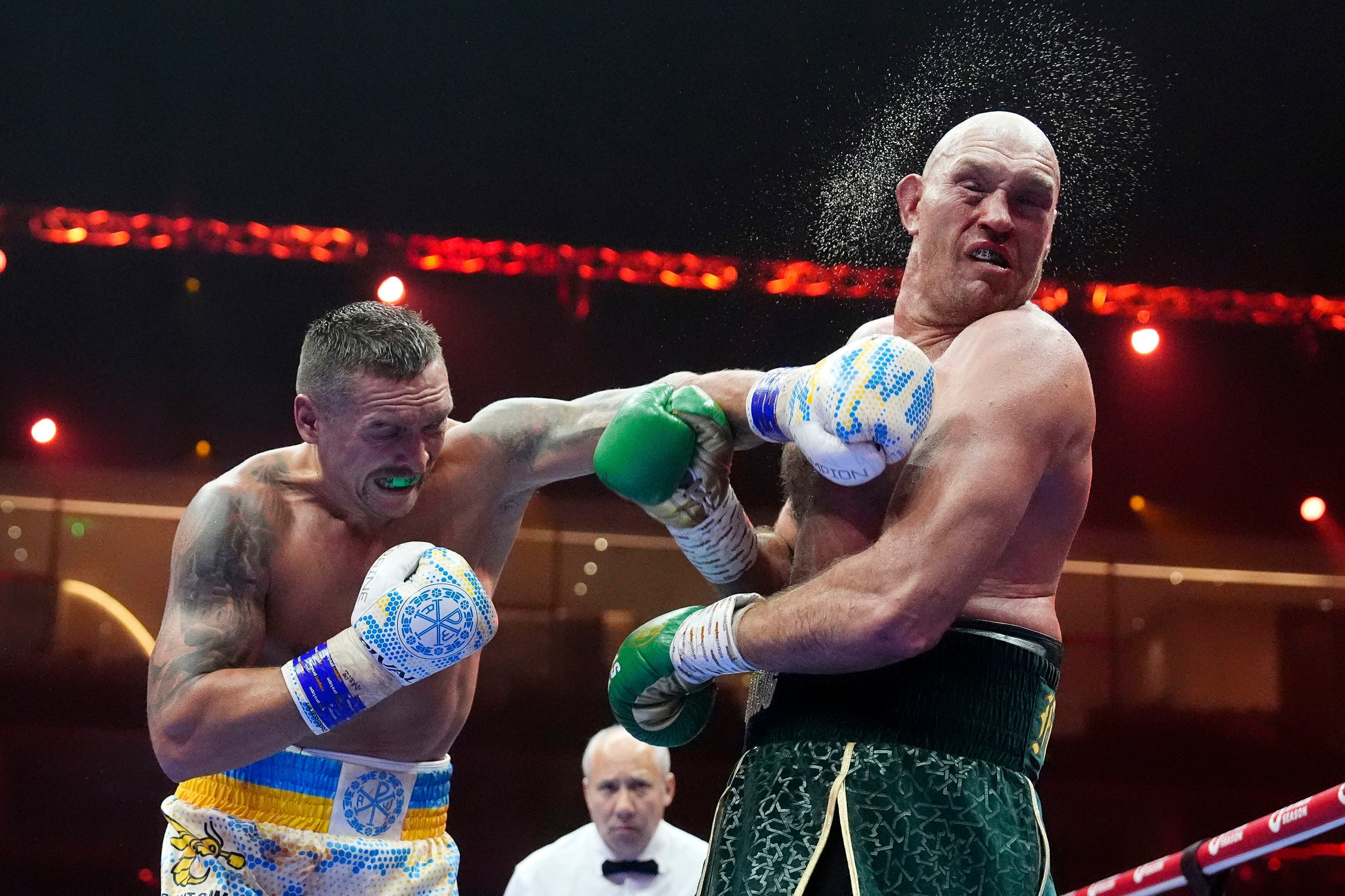 El ucraniano Oleksandr Usyk propina un golpe al británico Tyson Fury, durante su pelea por la unificación del título de los pesados, la madrugada del domingo 19 de mayo, en Riad