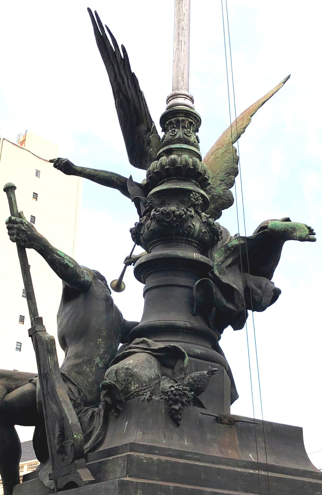 Parte posterior de El Comercio Marítimo, donde se ve la figura masculina con el timón, y la cesta con el racimo de uvas y el ananás