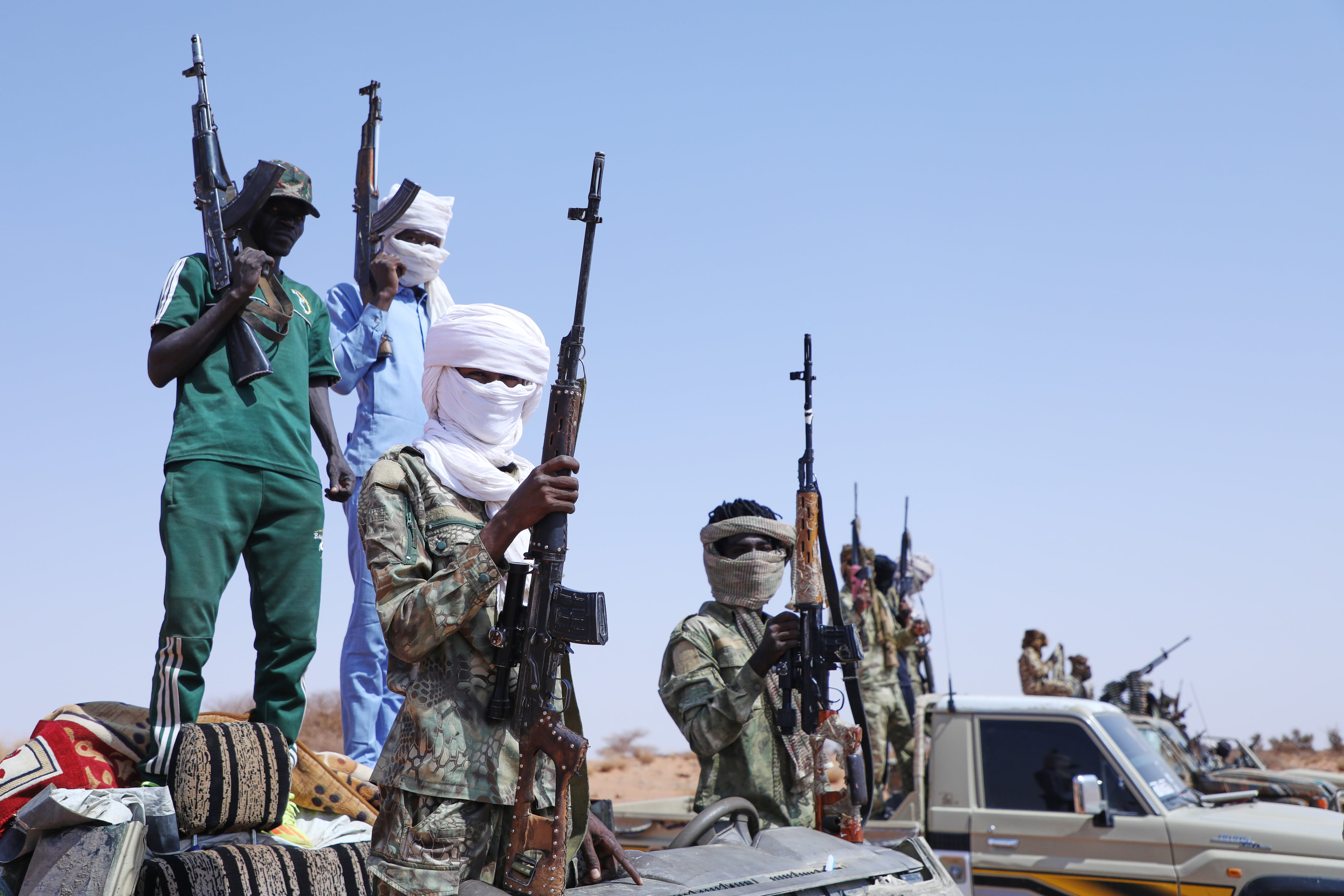 Desertores armados del grupo paramilitar Fuerzas de Apoyo Rápido (FAR) levantan sus ametralladoras, presuntamente para rendirse al Ejército sudanés, en Sudán