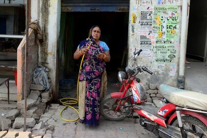 Rajpati Devi, de 45 años, mecánica de bicicletas, motos y gomería, posa en su taller al borde de la carretera en Allahaba, India