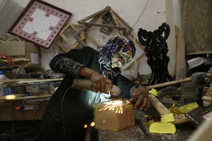 Amal Regaeg, una carpintera palestina de 40 años, trabaja en su tienda en el campo de refugiados de al-Nusairat, en el centro de la Franja de Gaza