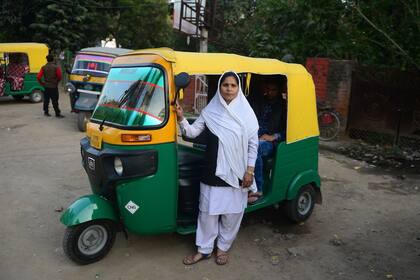 Tabasumm, 30, una conductora de auto de pasajeros, rickshaw, posa con su vehículo en Allahabad