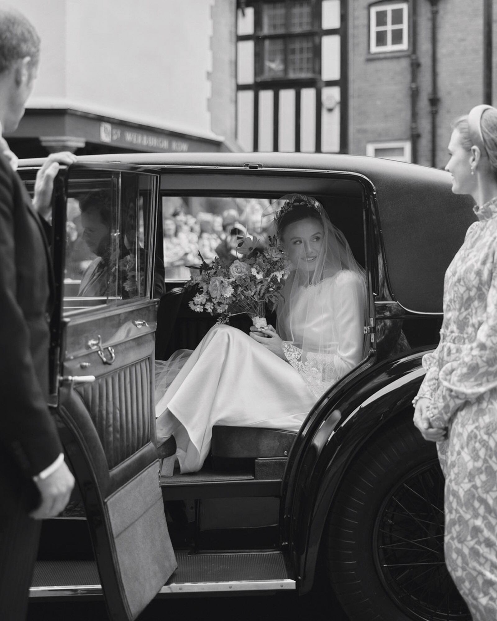 Una de las fotos oficiales de la boda en la que vemos a Olivia a punto de descender del Bentley de 1930 en el que llegó a la catedral de Chester para casarse con el soltero menor de 40 más rico de Gran Bretaña. 
