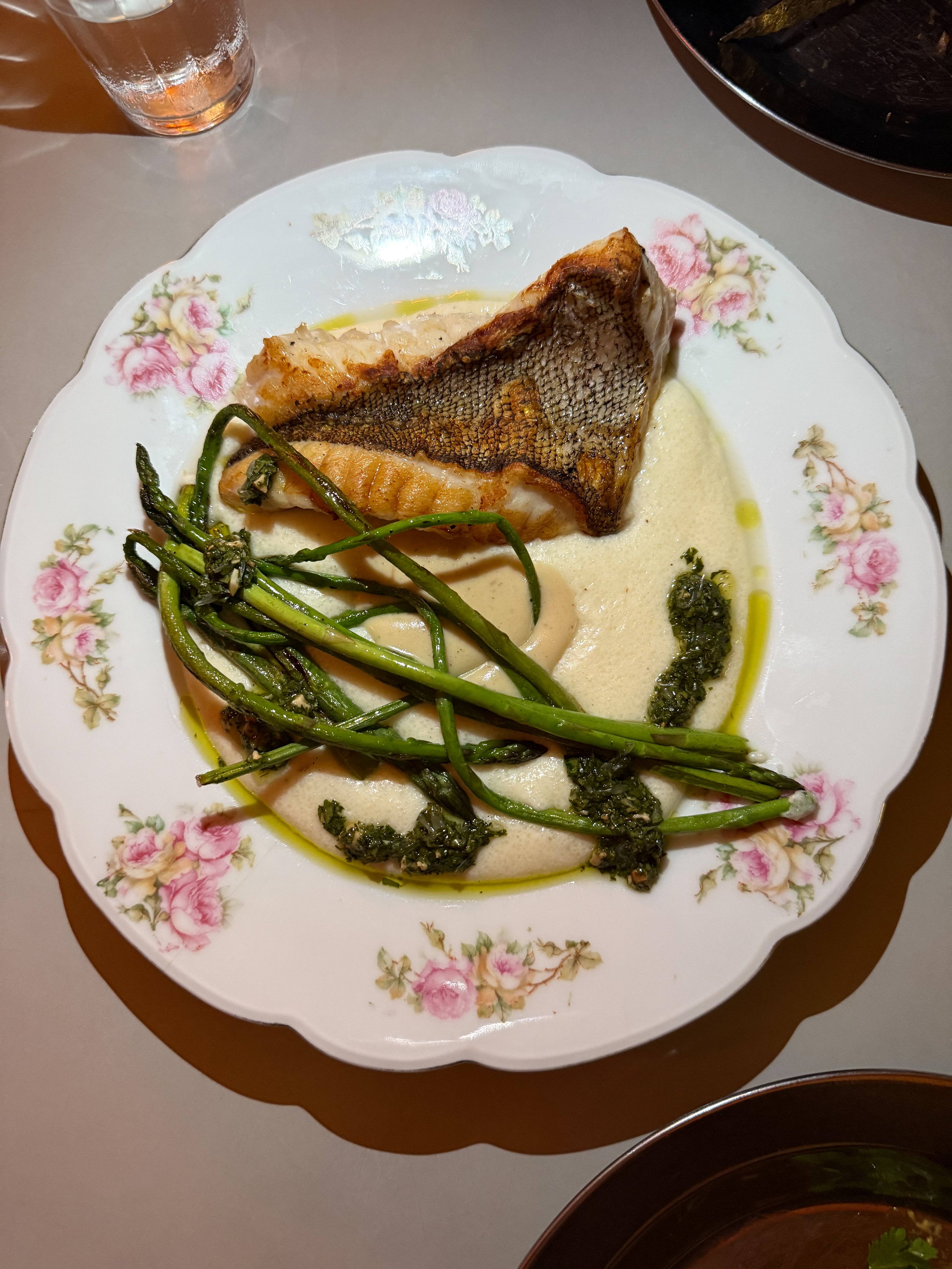 La chernia se sirve con polenta blanca, espárragos y gremolata