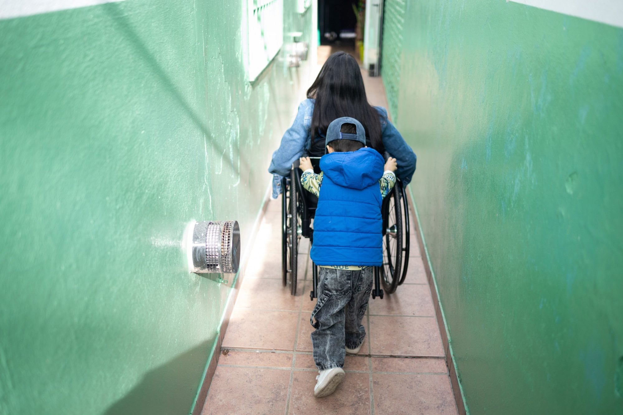 Lionel ayuda a su mamá con su silla de ruedas; para él es un juego más