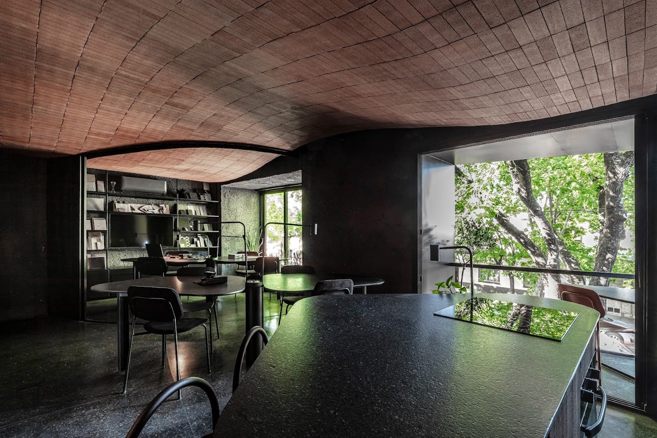 El estudio mantiene la continuidad de un cielorraso curvo de ladrillo que cubre todo el ambiente y se deja ver desde la calle